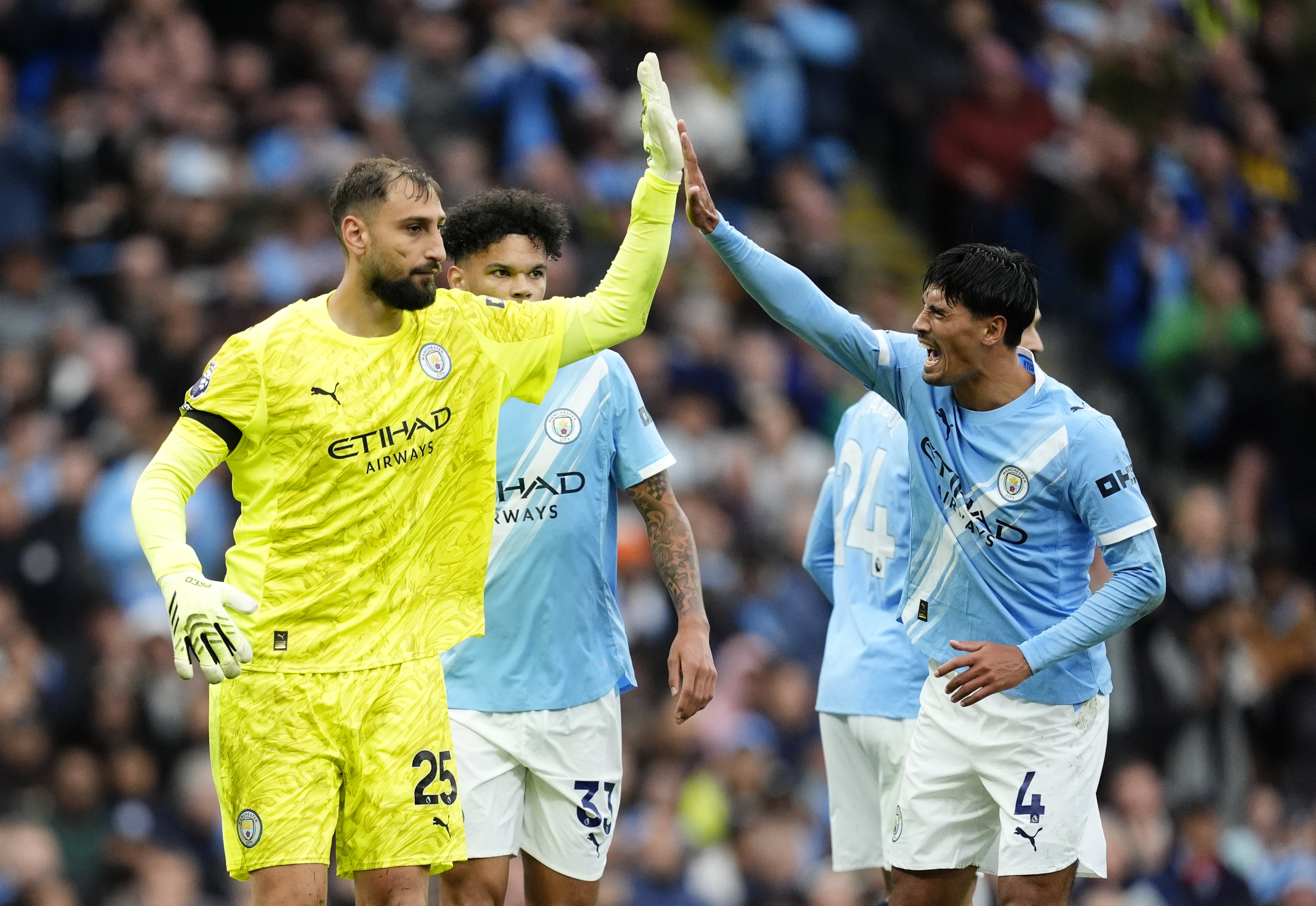 Manchester City’s Tijjani Reijnders, right, high-fives goalkeeper Gianluigi Donnarumma after a save