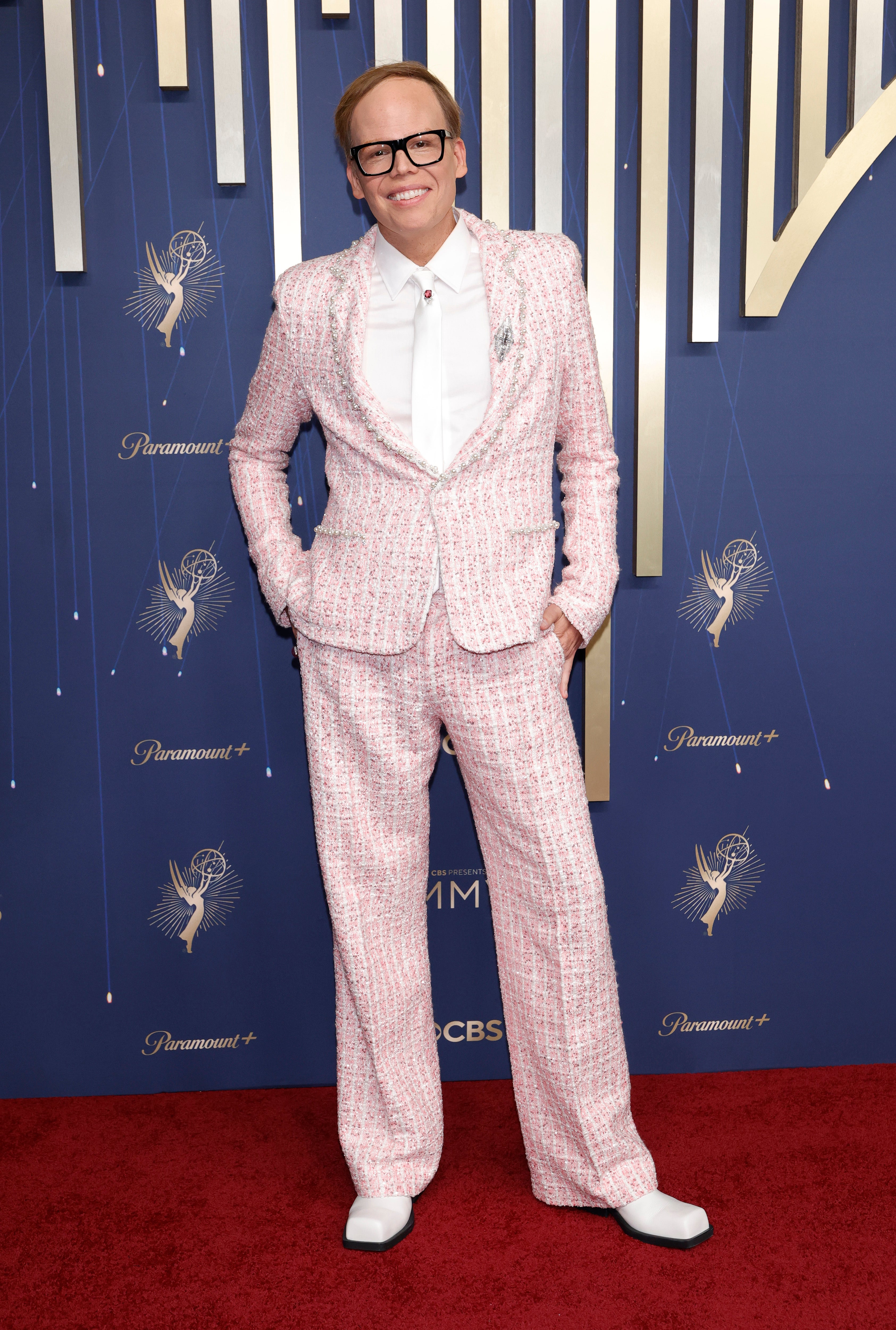 Actor Jeff Hiller kept his look simple but gorgeous: A white and pink tweed suit, with a white blouse to match. He added some flair to his white tie with a red pendant, along with a silver brooch on his jacket. Meanwhile, his white shoes with black trim gave a retro ‘80s vibe