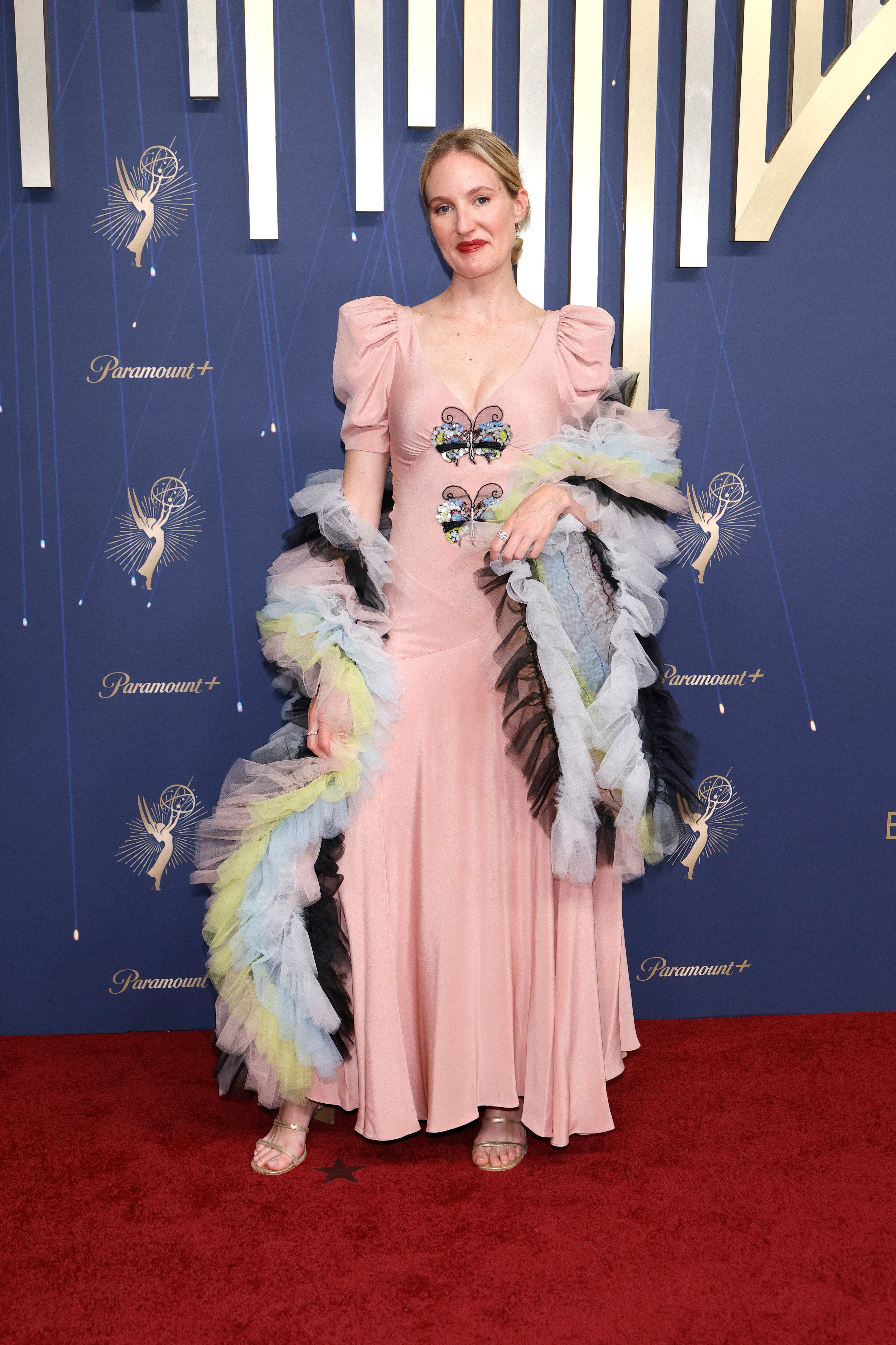 Murphy, an Australian film director, seemed to be going for some kind of animal theme as her pale pink gown with capped sleeves randomly had two multi-colored butterflies down her chest, with a matching boa that was distracting