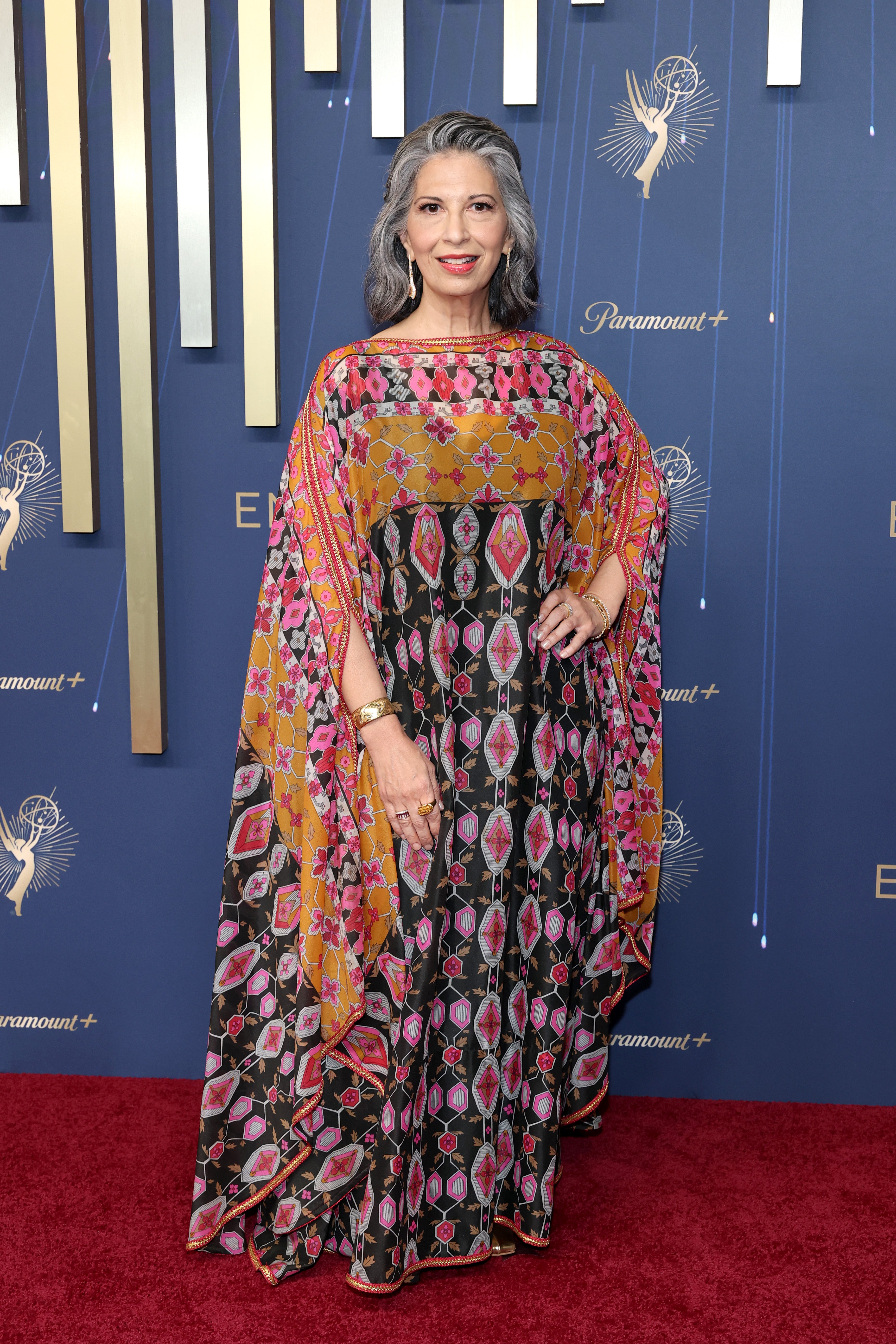 One of the night's most anticipated moments is the 'Gilmore Girls' reunion. Rose Abdoo, who played Gypsy on the beloved series, wore a multi-colored caftan-style dress. Adding to her vibrant look were red lipstick, a gold watch, and hoop earrings
