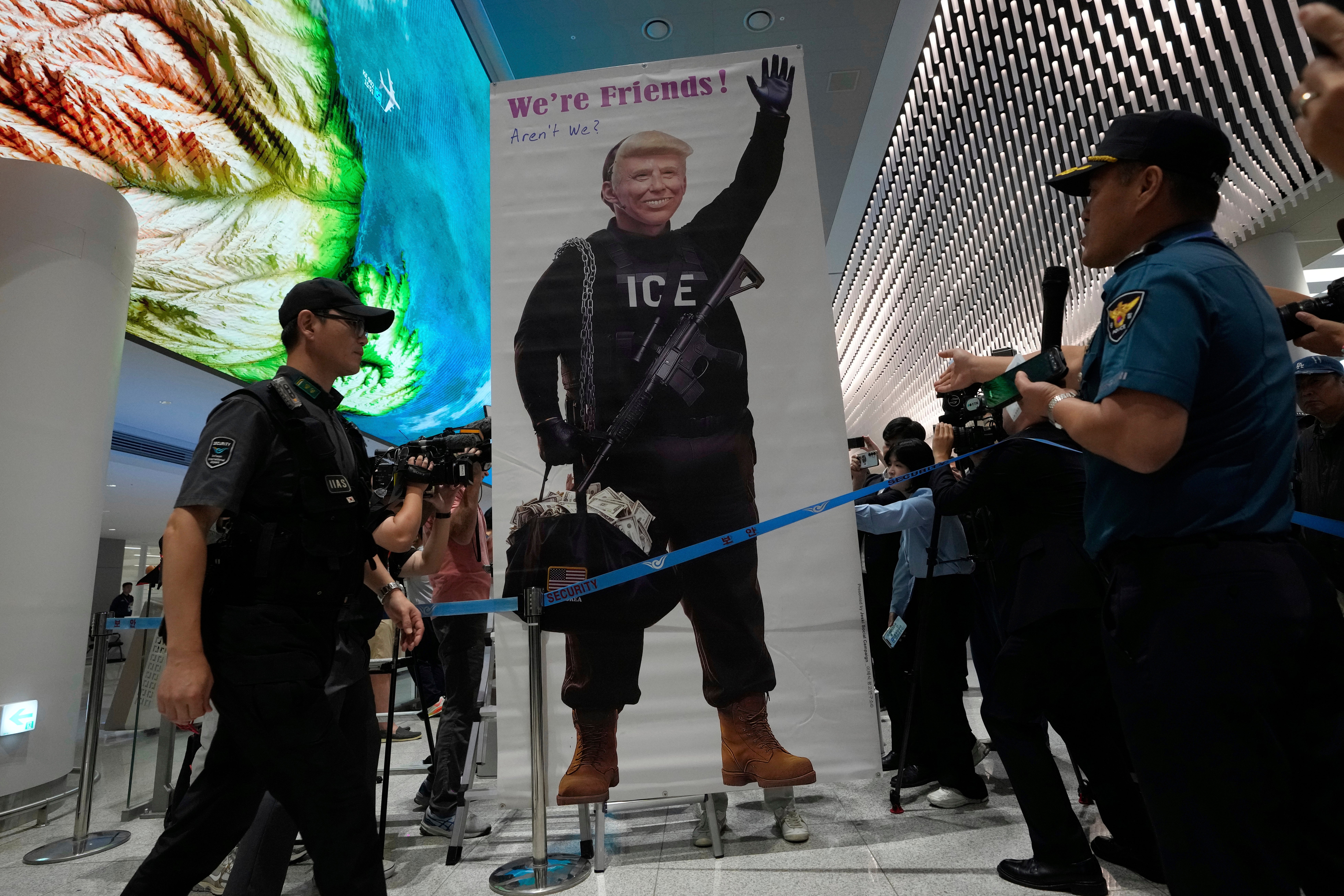A banner showing a depiction of US President Donald Trump is displayed by a protester at Incheon International Airport