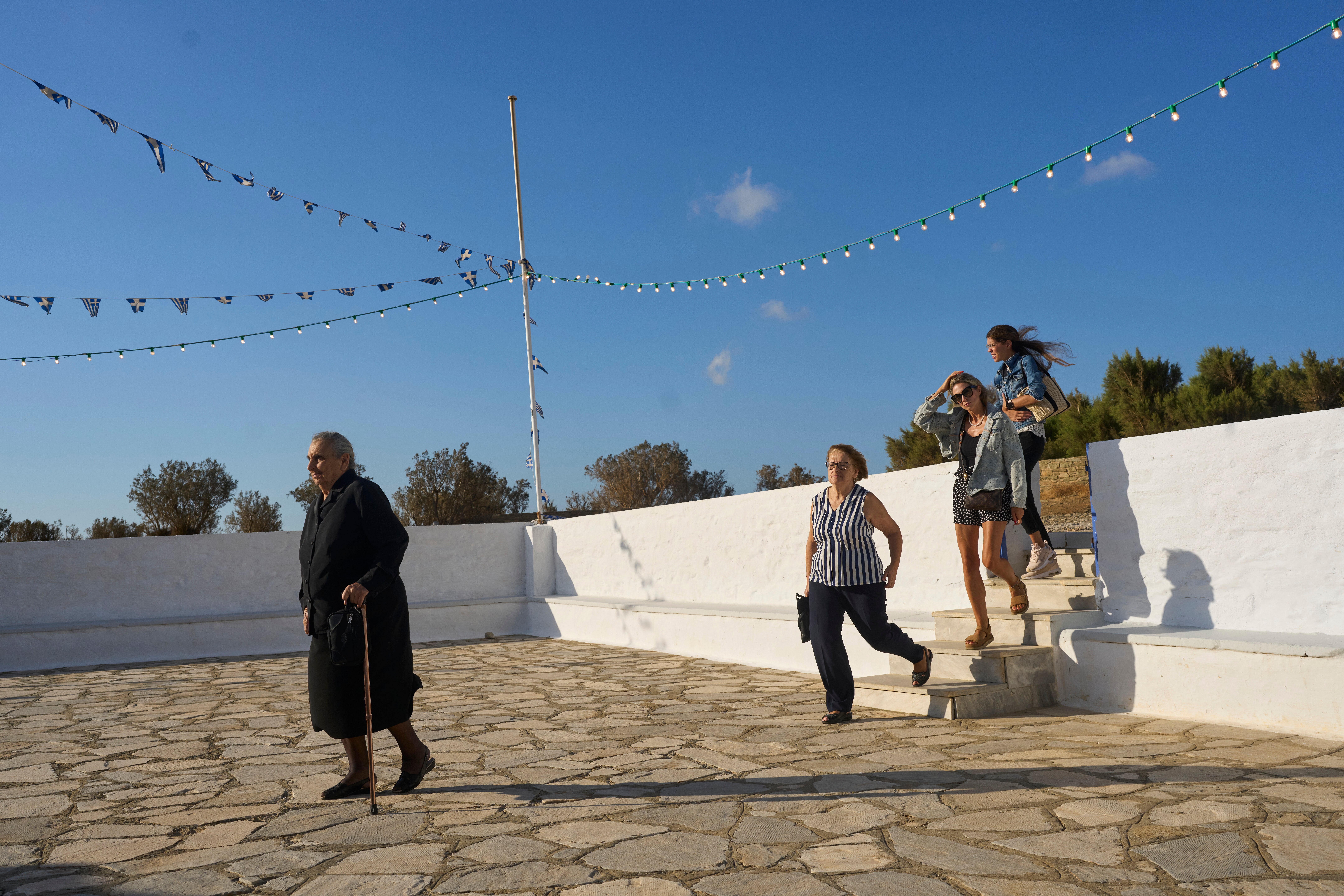 Worshippers arrive at the family-owned Agios Sostis chapel for for a liturgy service on the island of Tinos, Greece, Monday Sept. 8, 2025. (AP Photo/Petros Giannakouris)