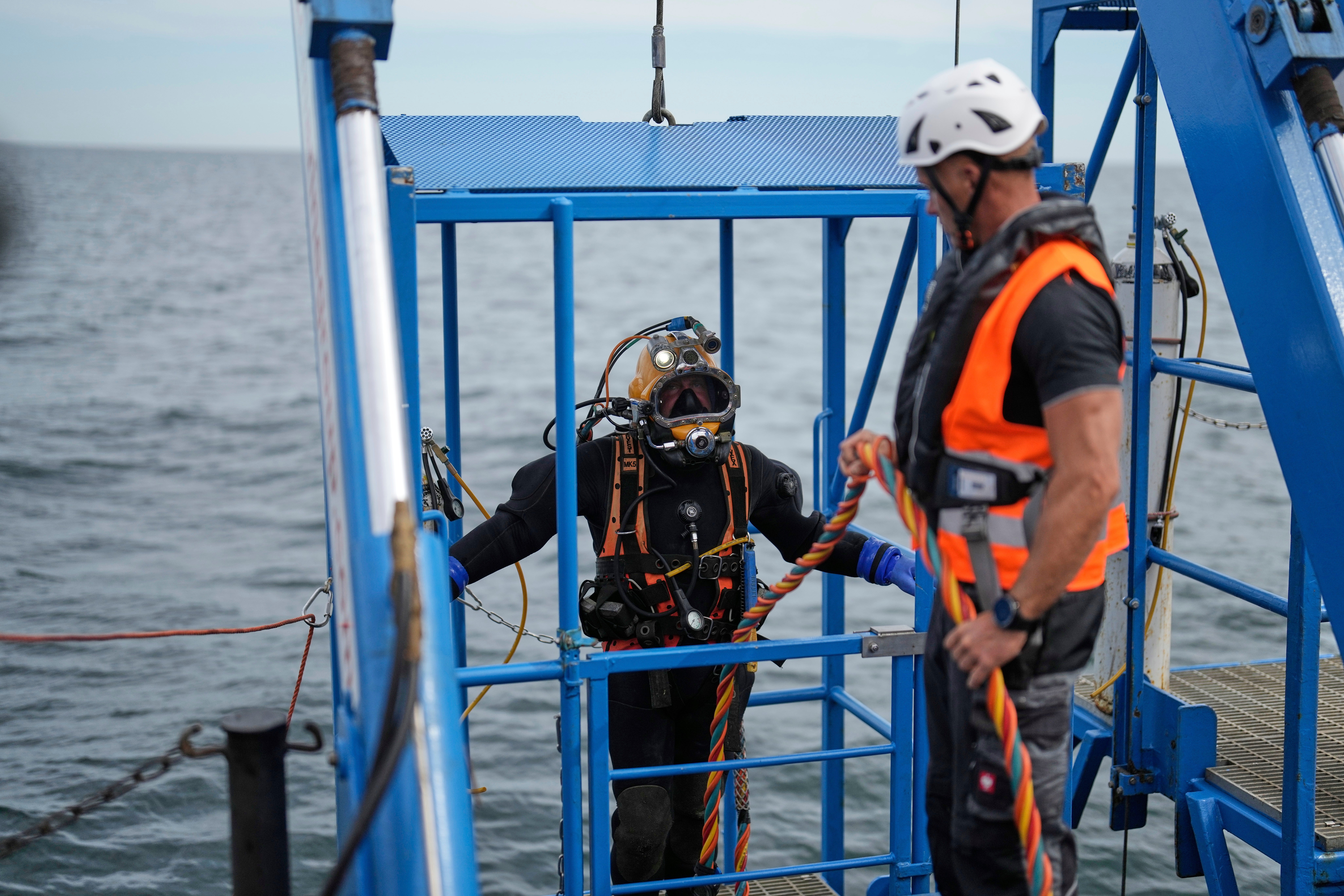 A diver is lowered into the water during a press tour to show the recovering of ammunition from World War II in the Baltic Sea near Boltenhagen, Germany