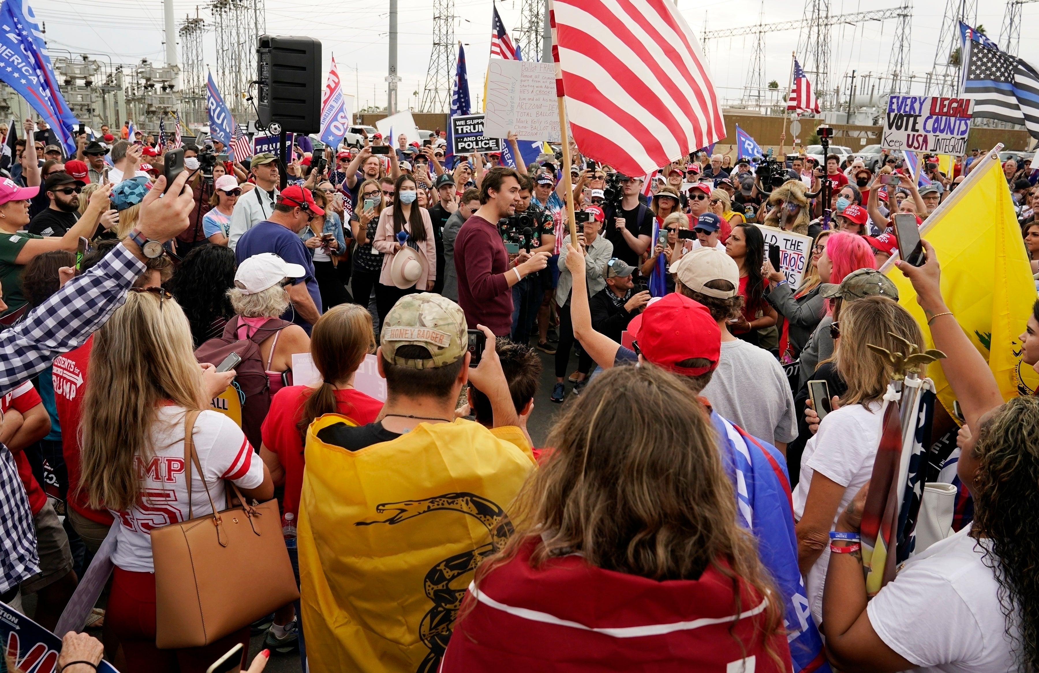 Charlie Kirk, center, conservative activist and founder of Turning Point USA, speaks to supporters of President Donald Trump at a rally, Nov. 6, 2020, in Phoenix. (AP Photo/Ross D. Franklin, File)