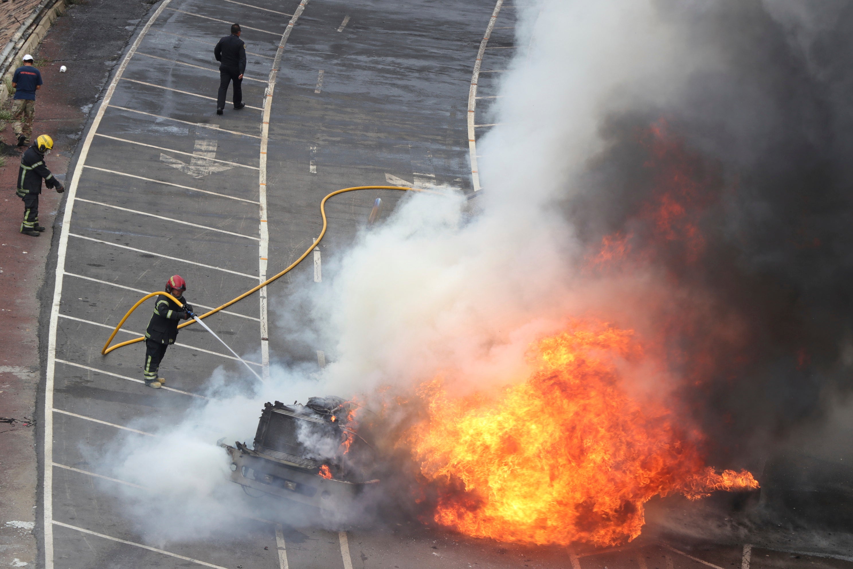 A firefighter extinguishes a fire after a gas tanker exploded under a highway overpass in Mexico City, Wednesday, Sept. 10, 2025