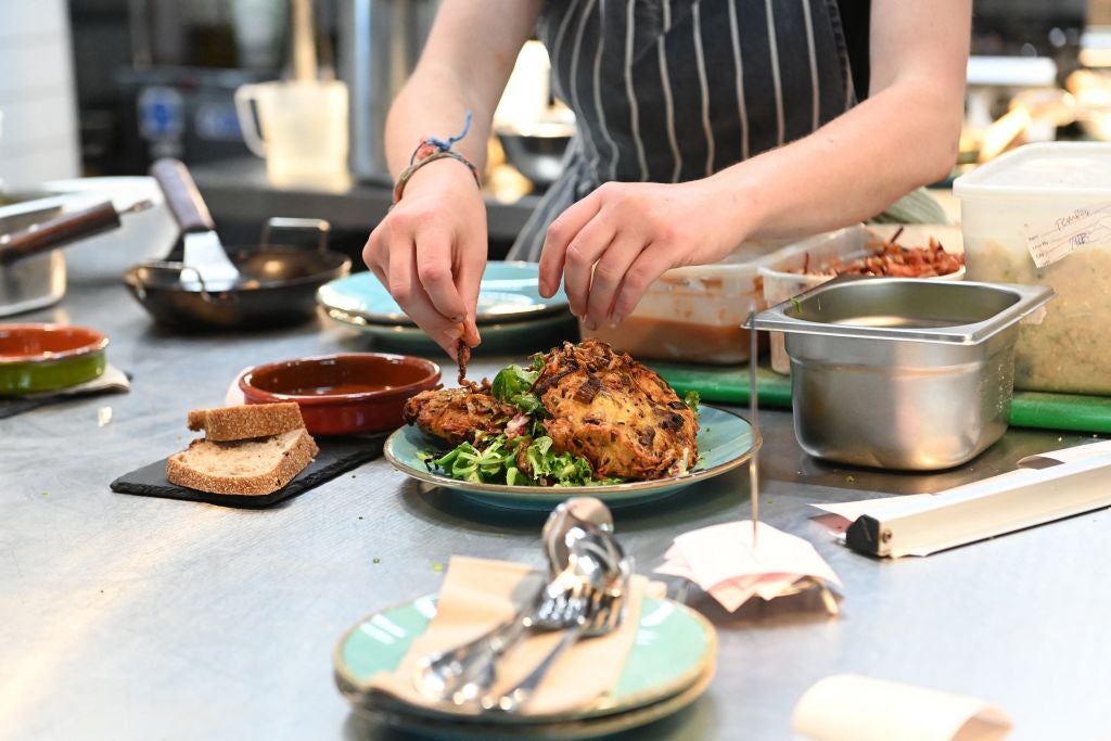 A staffer prepares food at The Canteen restaurant, one of the first in the UK to place carbon footprint of its dishes on the menu besides the calories, in Bristol