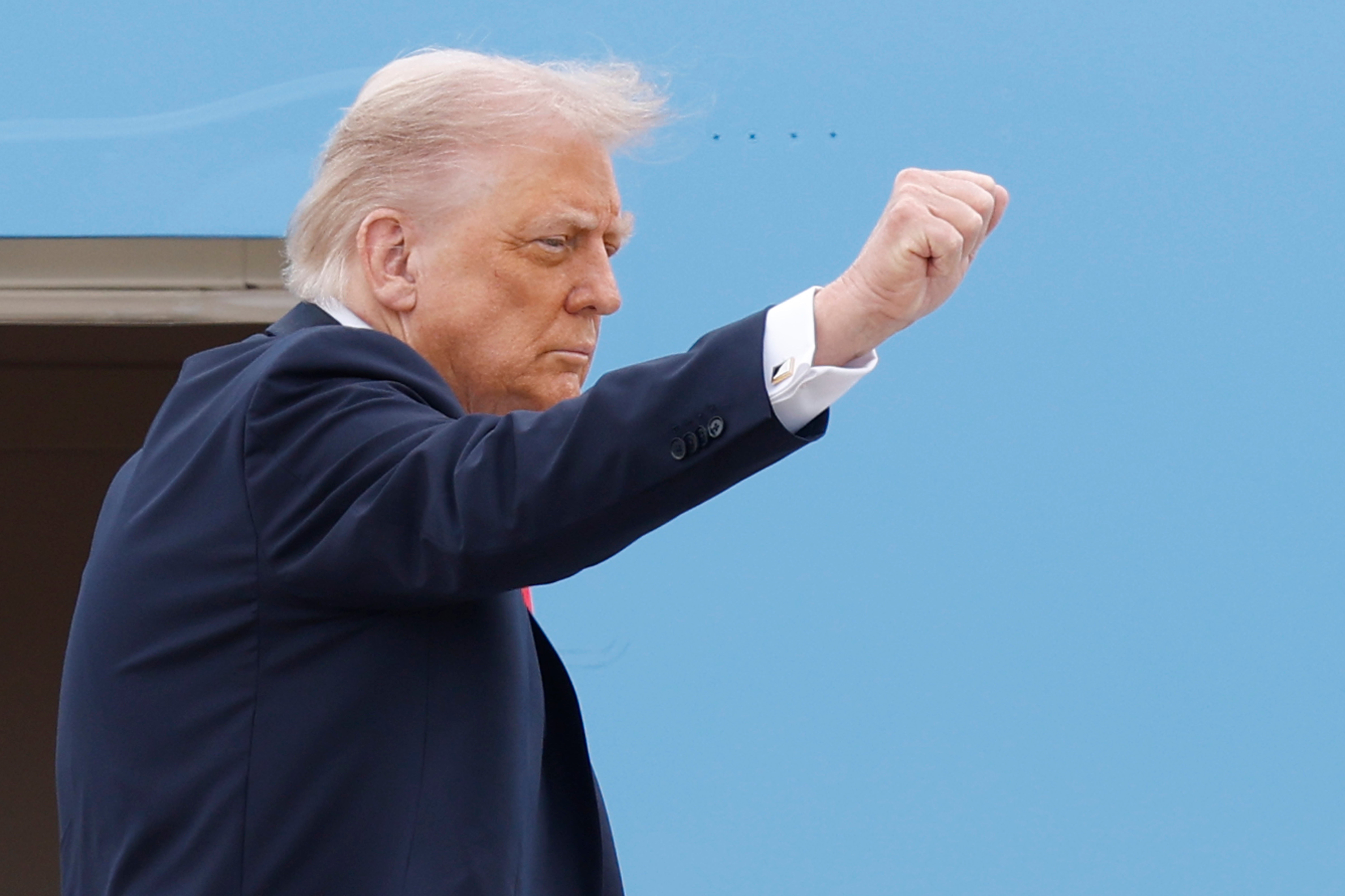 President Donald Trump gestures as he boards Air Force One at Joint Base Andrews en route to London Tuesday.