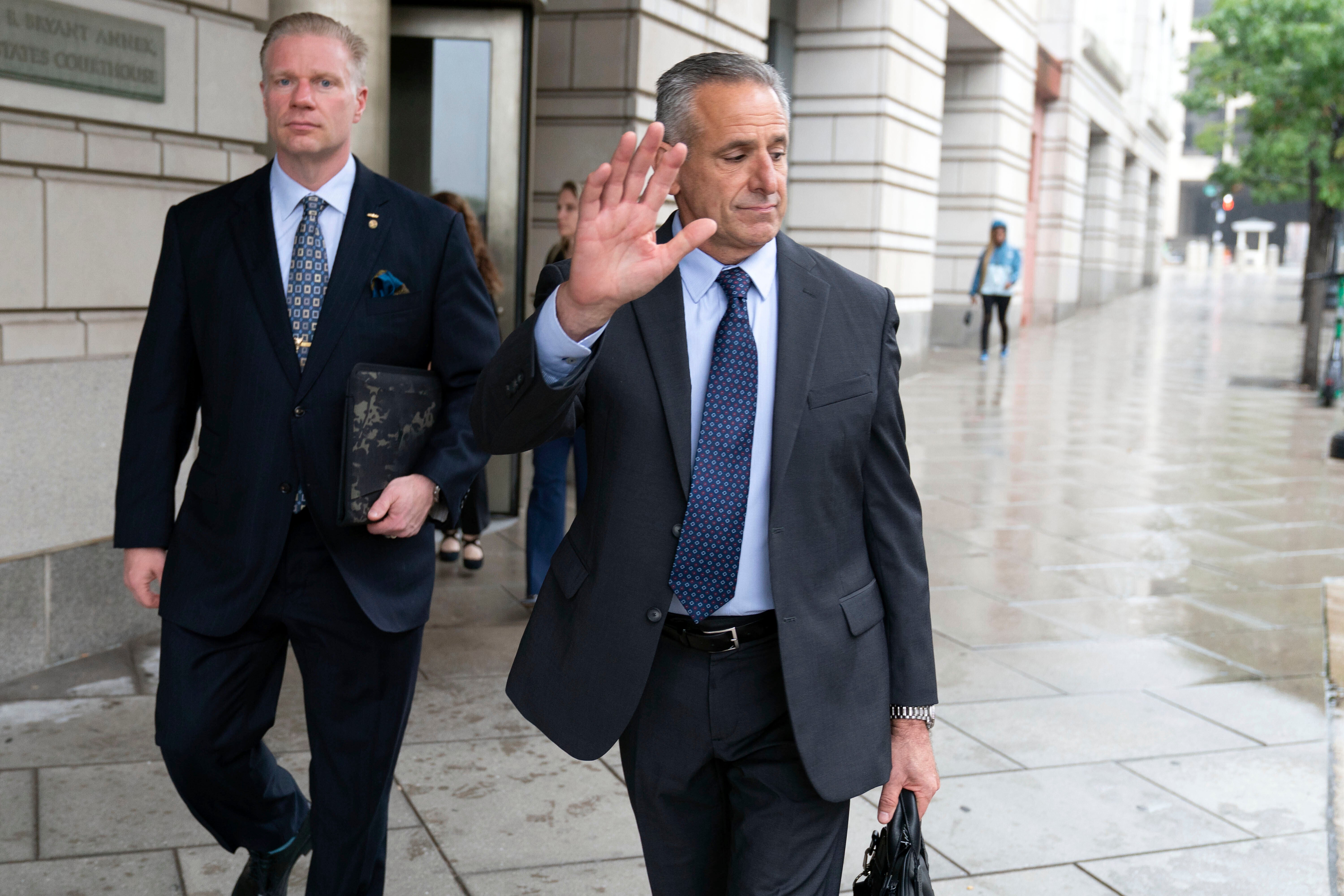 Retired Adm. Robert P. Burke, 63, right, walks out of the federal courthouse after being sentenced to six years in prison for his conviction on corruption charges, Tuesday, Sept. 16, 2025, in Washington. (AP Photo/Jose Luis Magana)