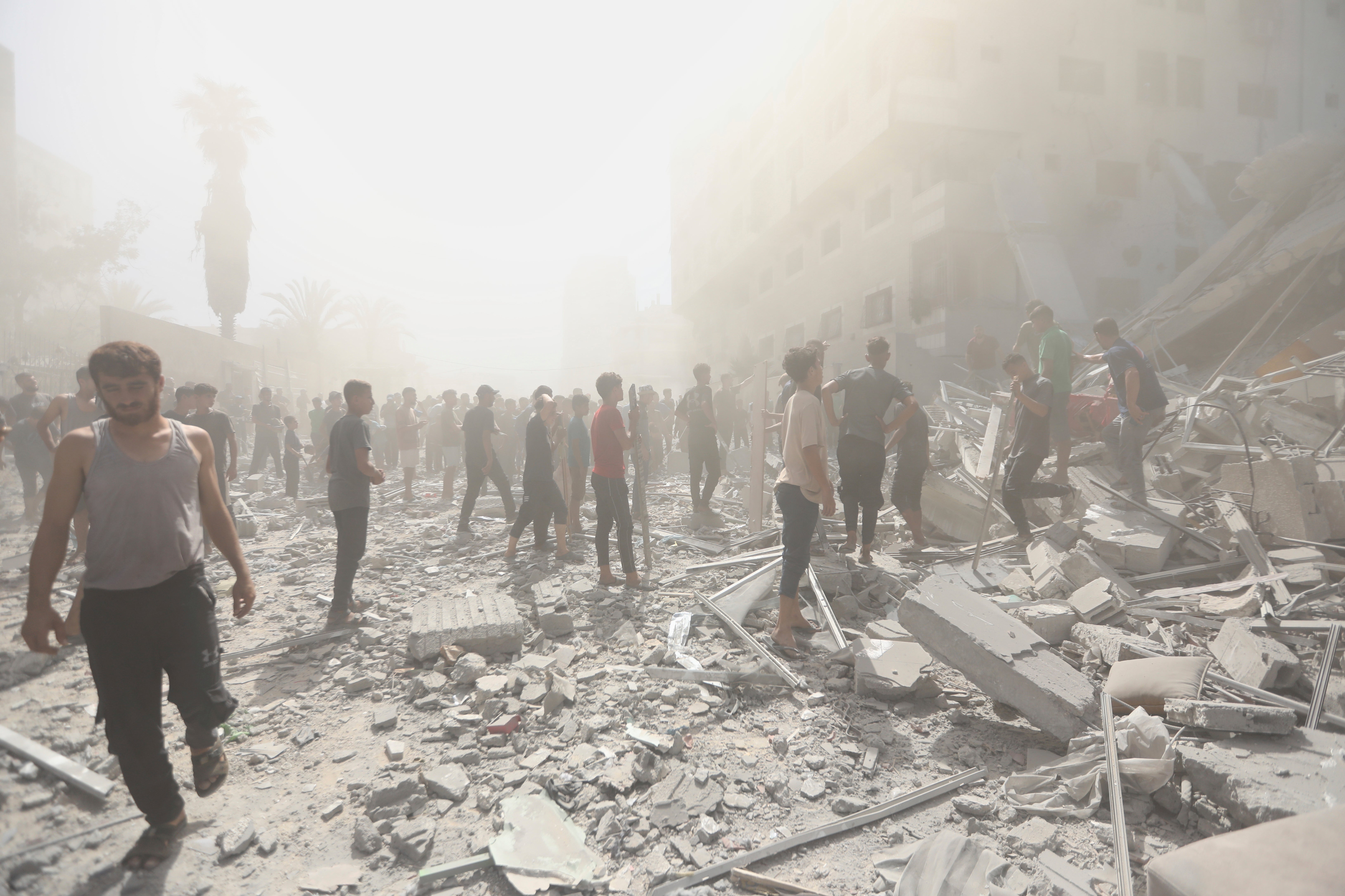 Palestinians inspect the remains of a building destroyed by an Israeli attack on Gaza City on Sunday