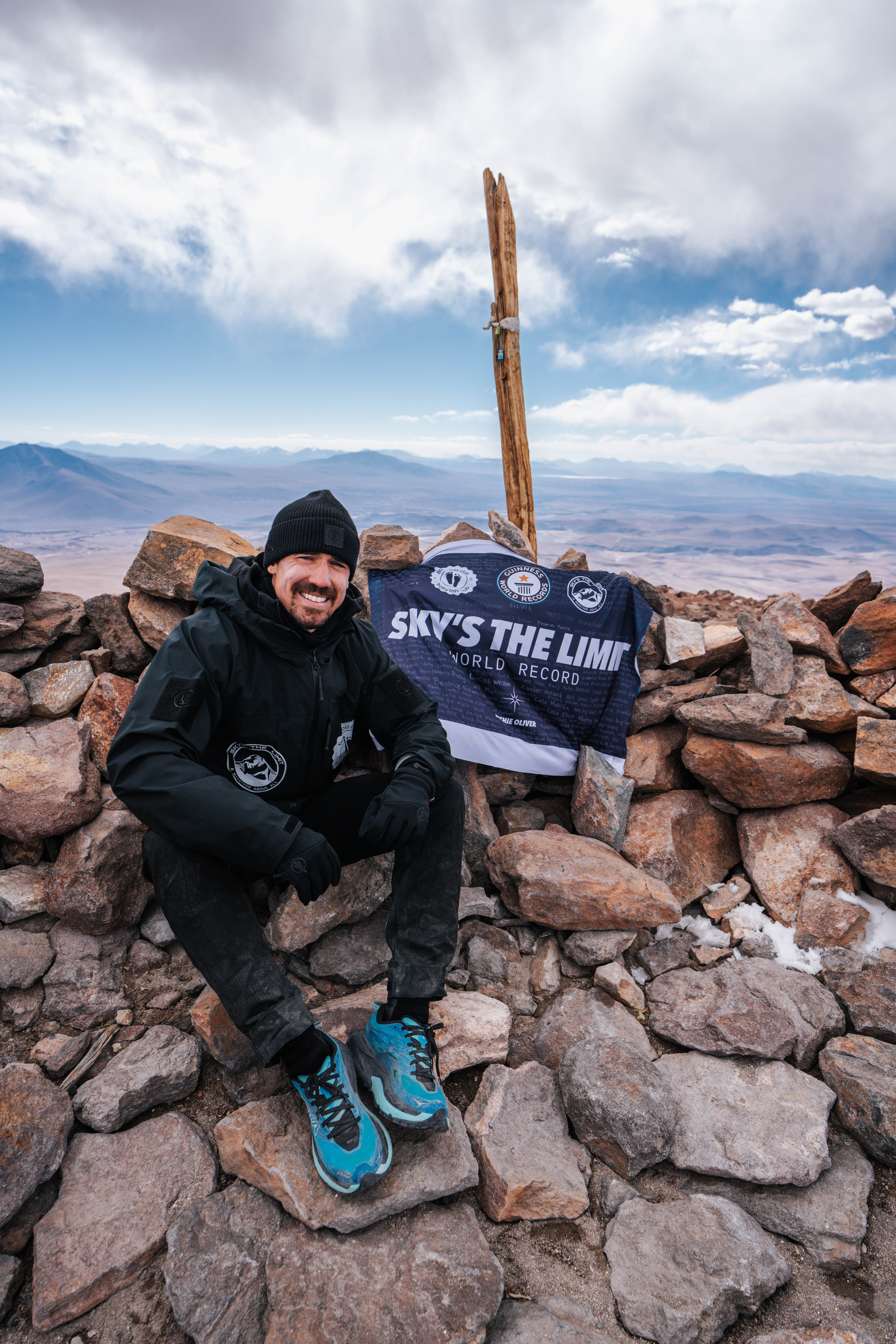 Joshua Patterson sits at the summit after a world-record breaking marathon run over a volcano