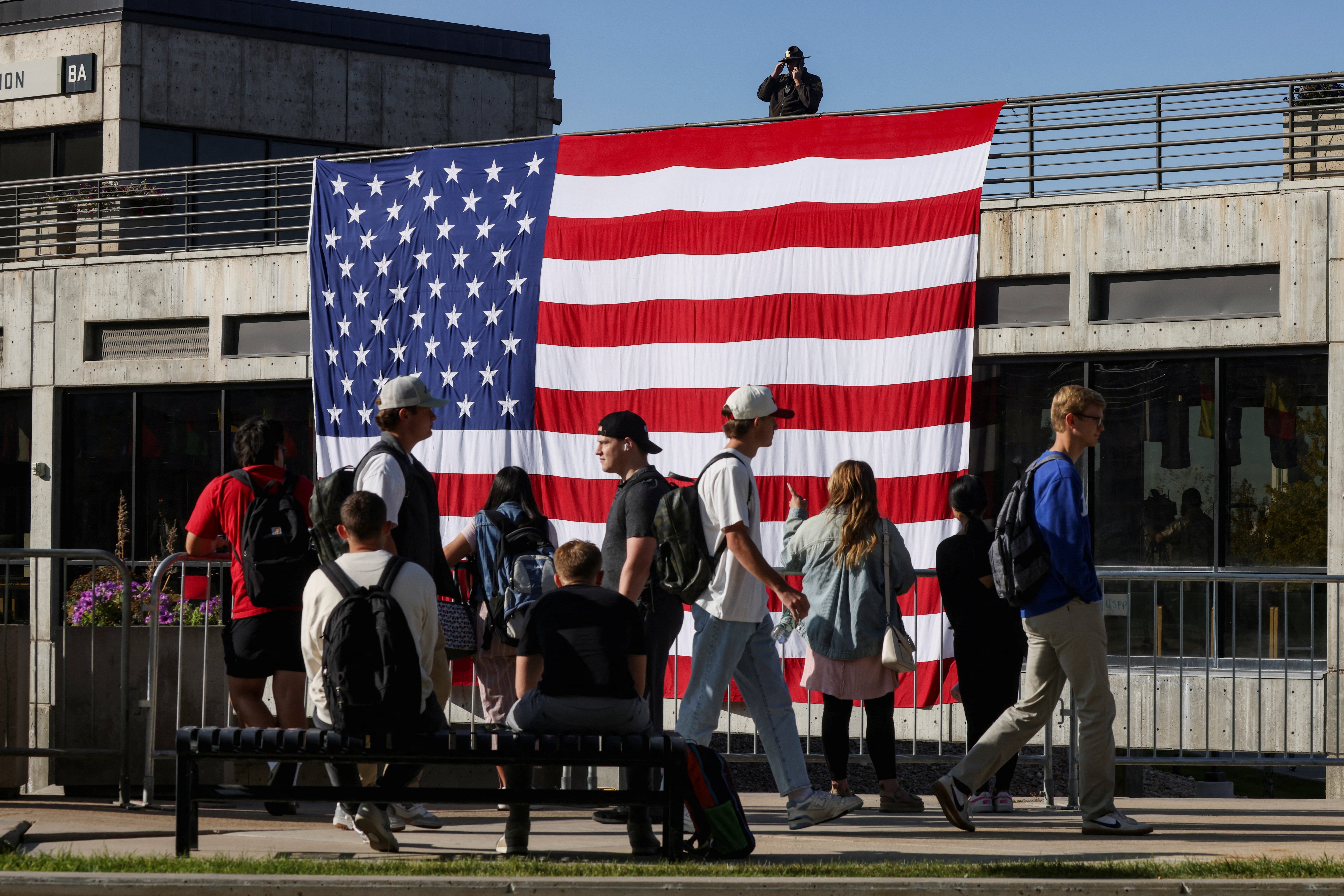 Students walk past a U.S. flag on the Utah Valley University campus as classes resumed on Wednesday