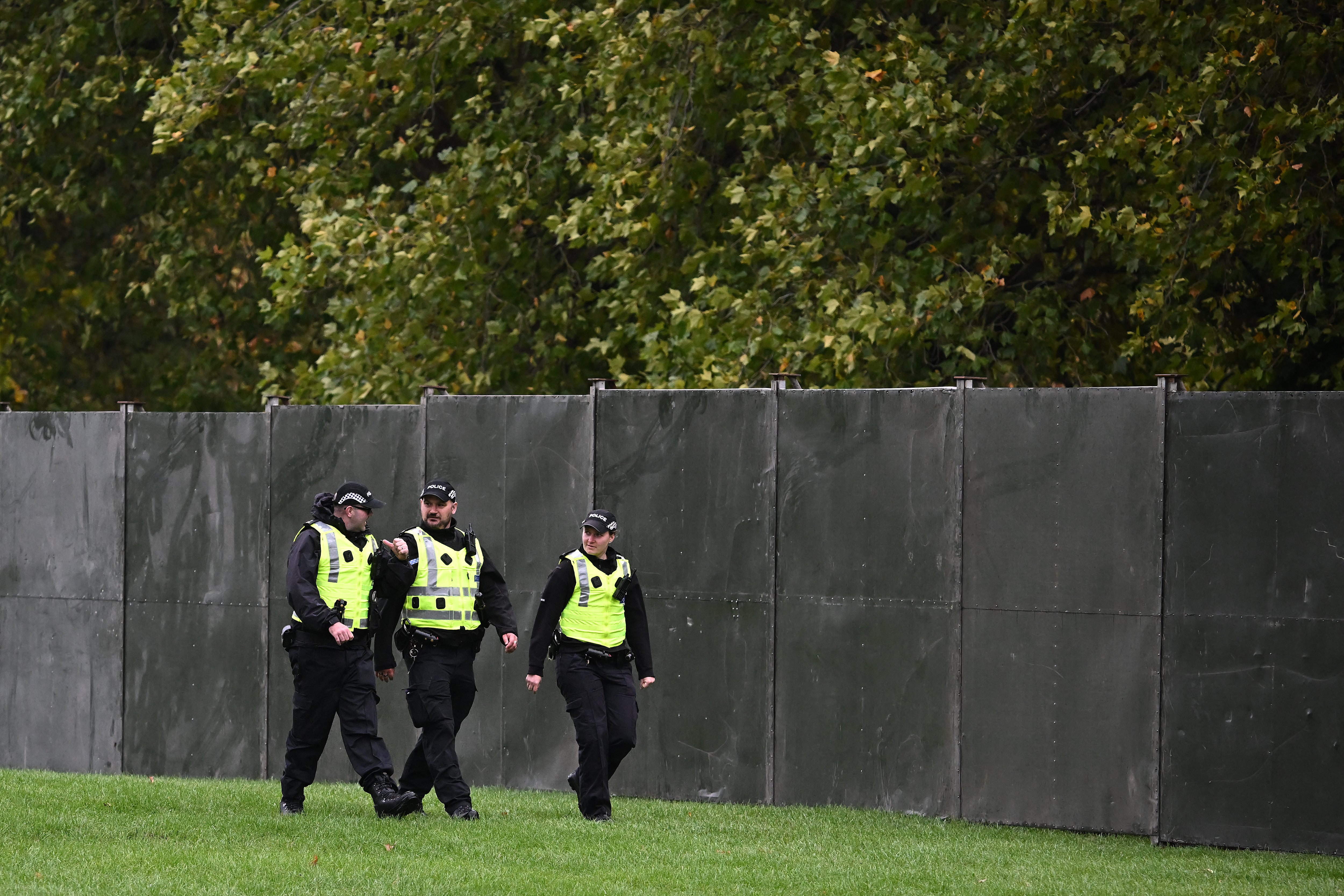 Police officers patrol a temporary fence, blocking off the Long Walk in the grounds of Windsor Castle, in Windsor, on September 17, 2025, during US President Donald Trump's second State Visit to the UK