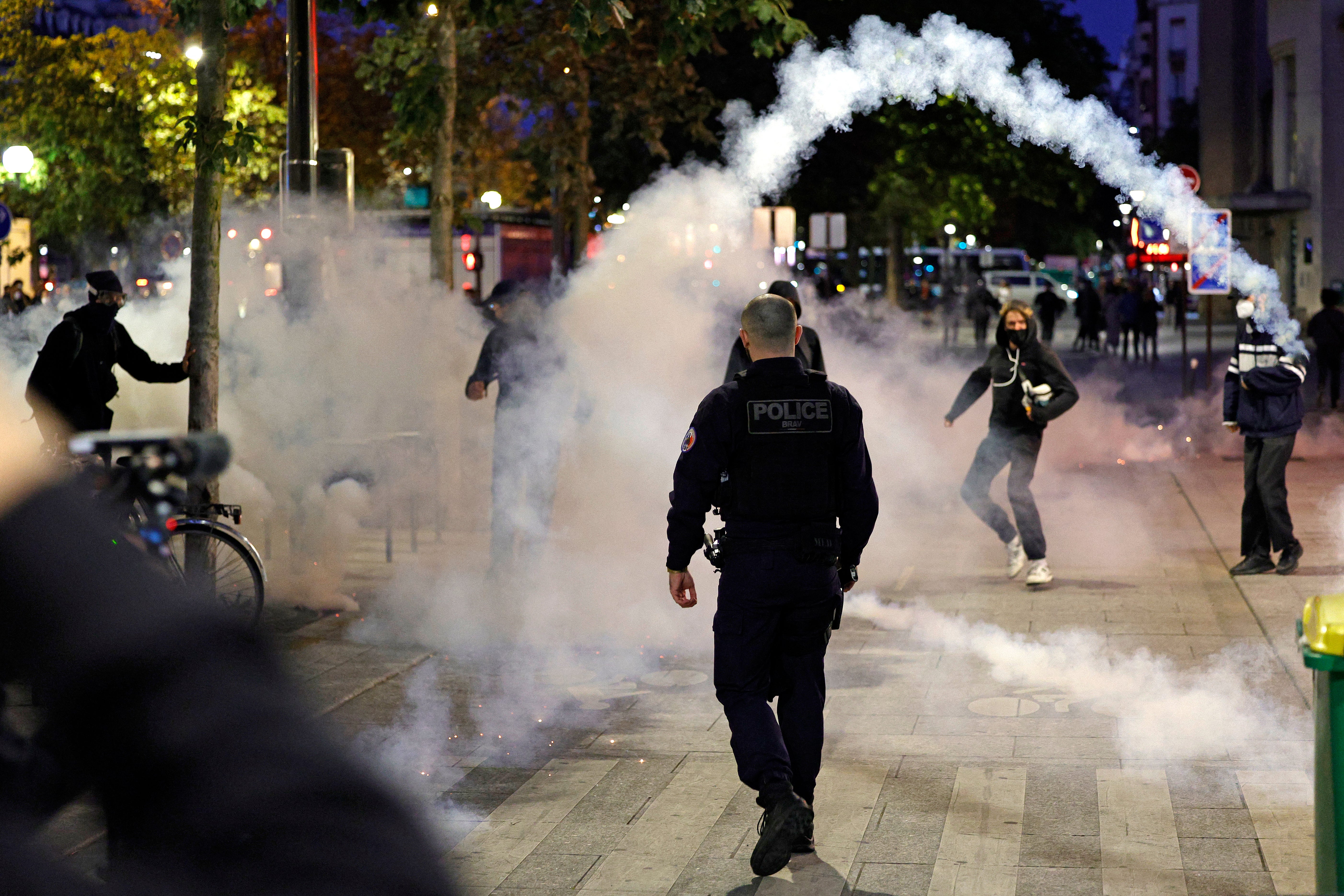 A teargas canister is thrown as police and demonstrators clash in Paris, on 18 September