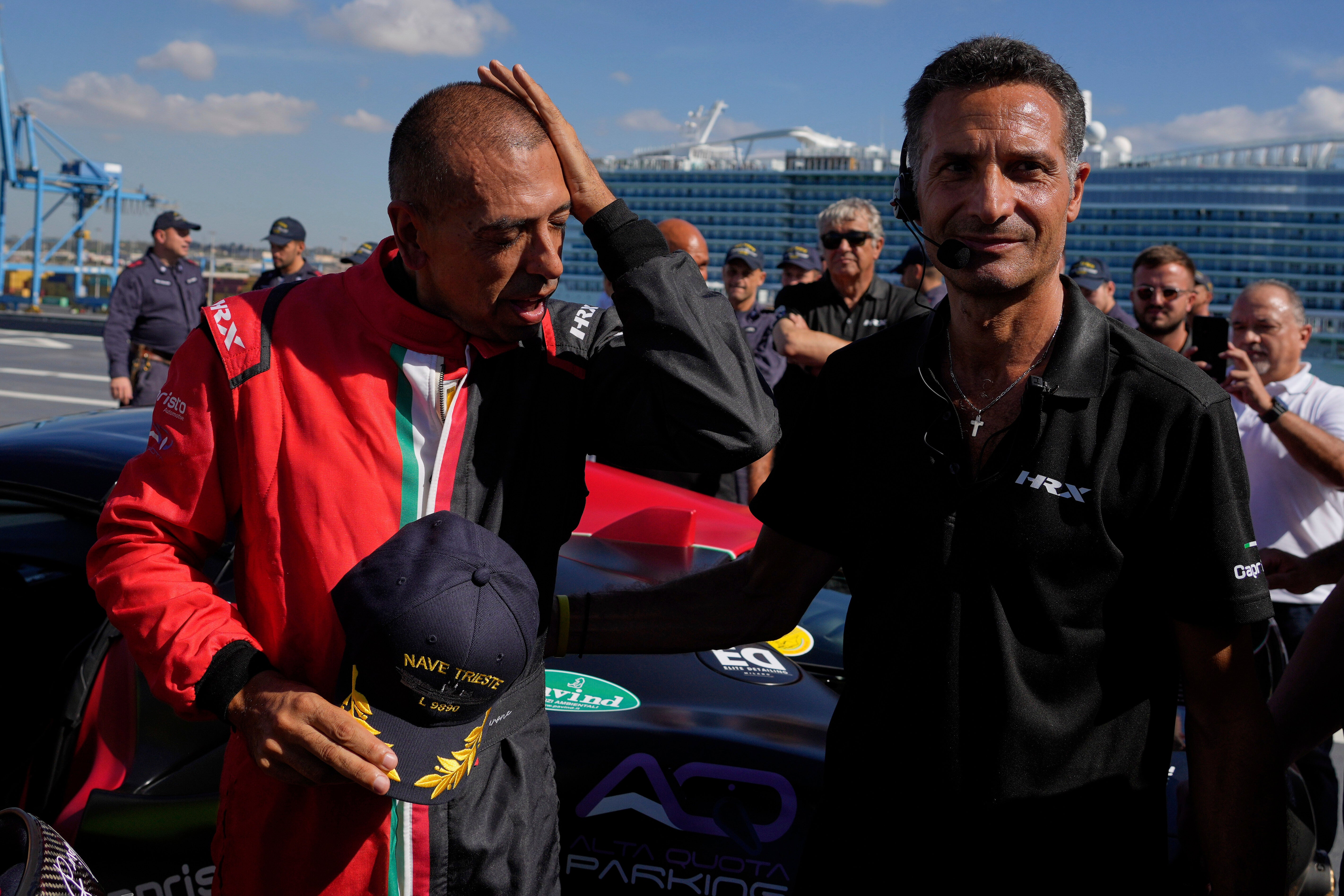 Italian driver Fabio Barone wipes his forehead after breaking his own speed record on a ship, at the wheel of a Ferrari SF 90, on the flight deck of the Italian Navy aircraft carrier Nave Trieste, docked at the port of Civitavecchia, Thursday, Sept. 18, 2025. (AP Photo/Gregorio Borgia)