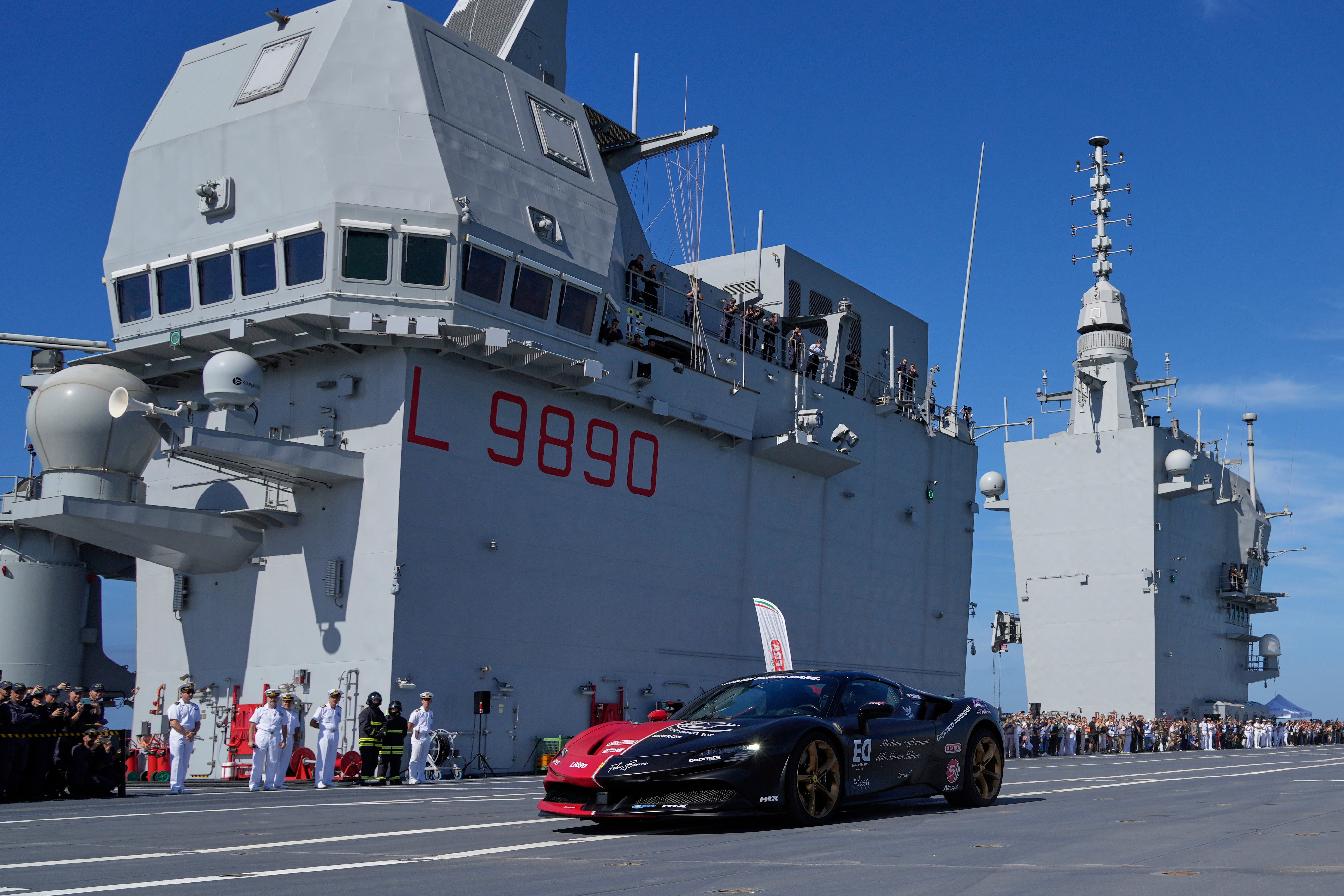 Italian driver Fabio Barone attempts to break his own speed record on a ship, at the wheel of a Ferrari SF 90, on the flight deck of the Italian Navy aircraft carrier Nave Trieste, docked at the port of Civitavecchia, Thursday, Sept. 18, 2025. (AP Photo/Gregorio Borgia)