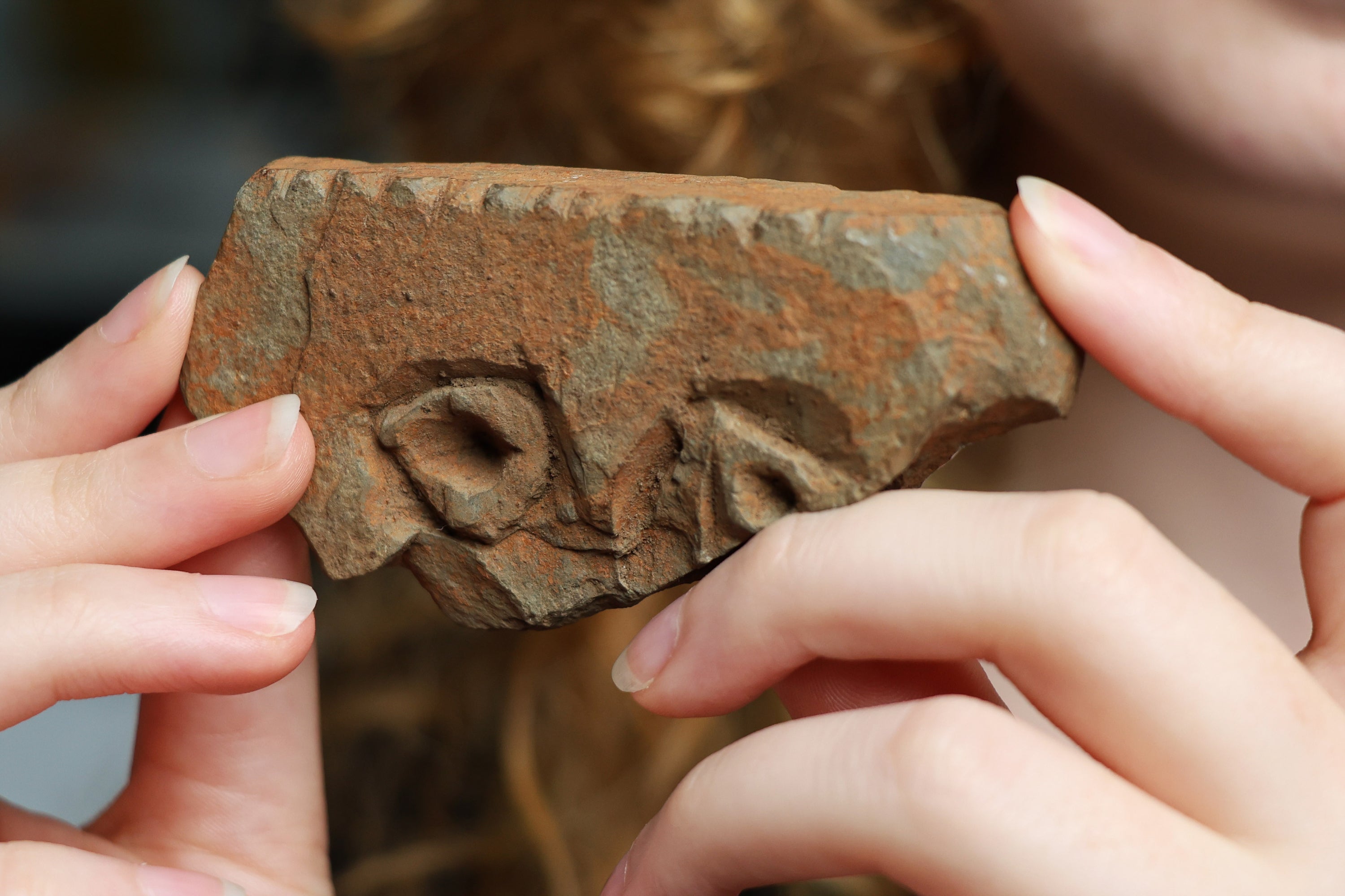 The object appears to be a carving with two eyes and a nose, leading experts to suggest it may depict a human face