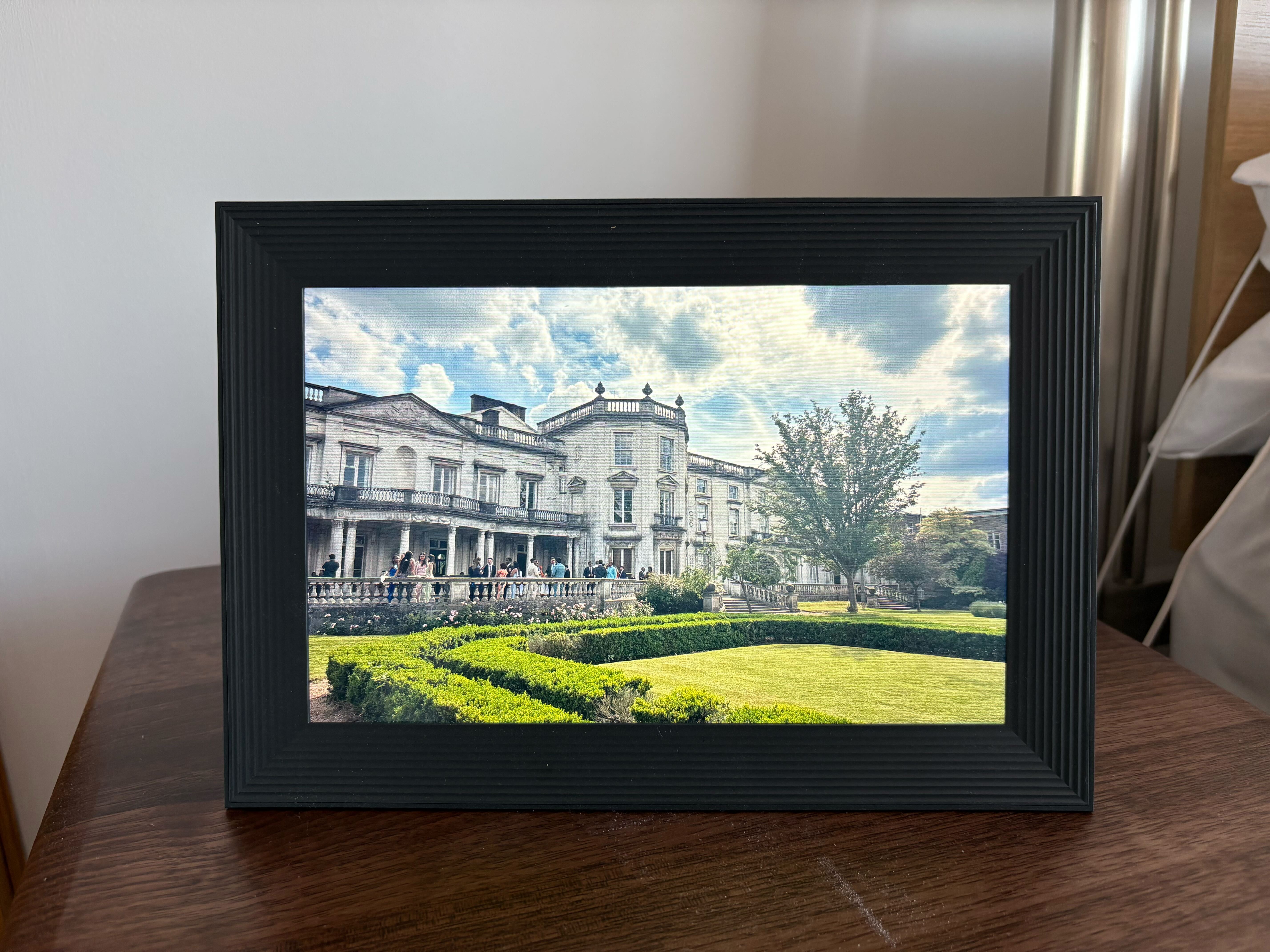 Aura carver digital picture frame on a bedside table