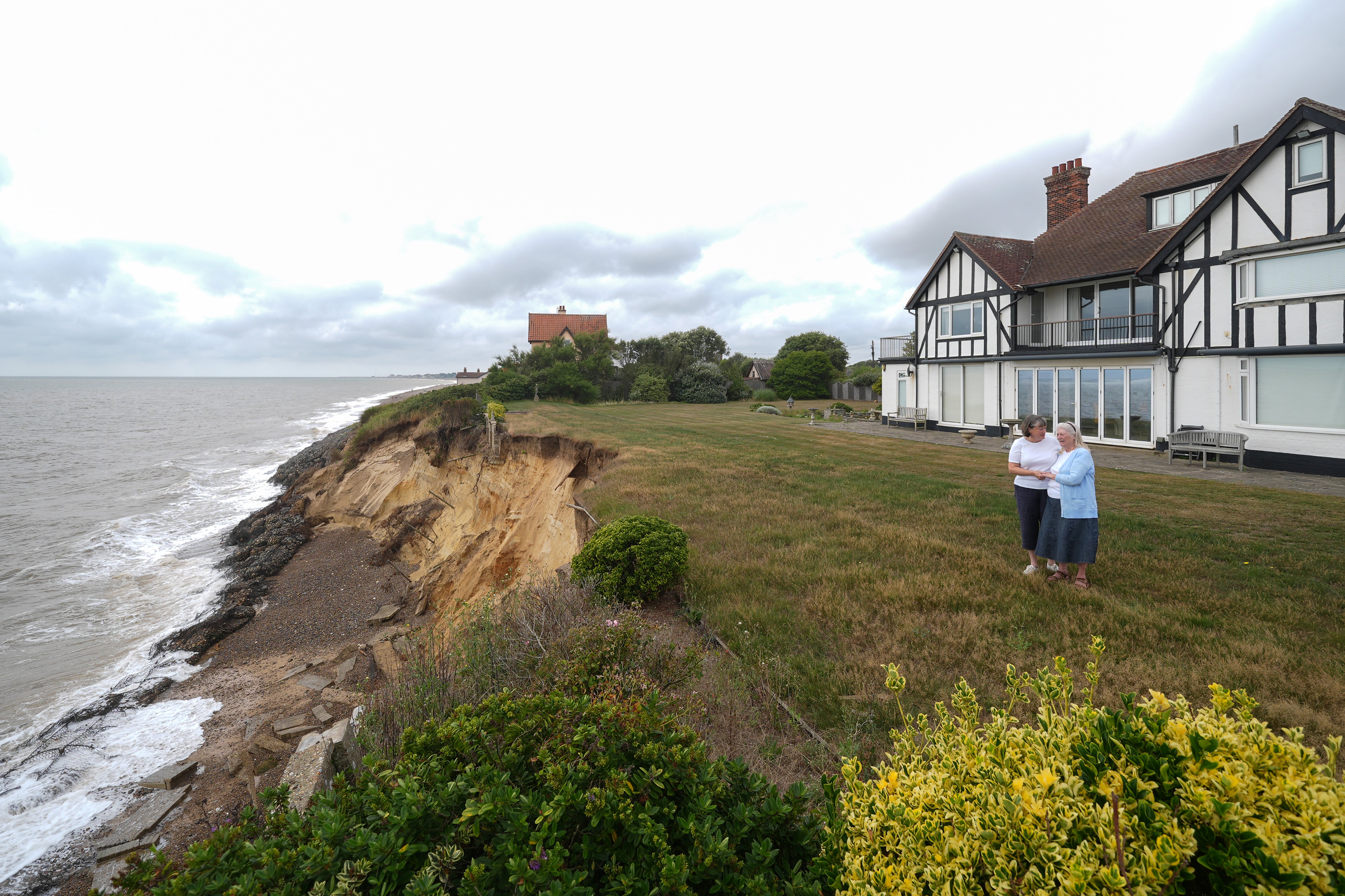Jean Flick, 88, with daughter Frances, 60, in the garden at her home in Thorpeness, Suffolk, which is at risk of falling into the sea following coastal erosion (Joe Giddens/ PA)