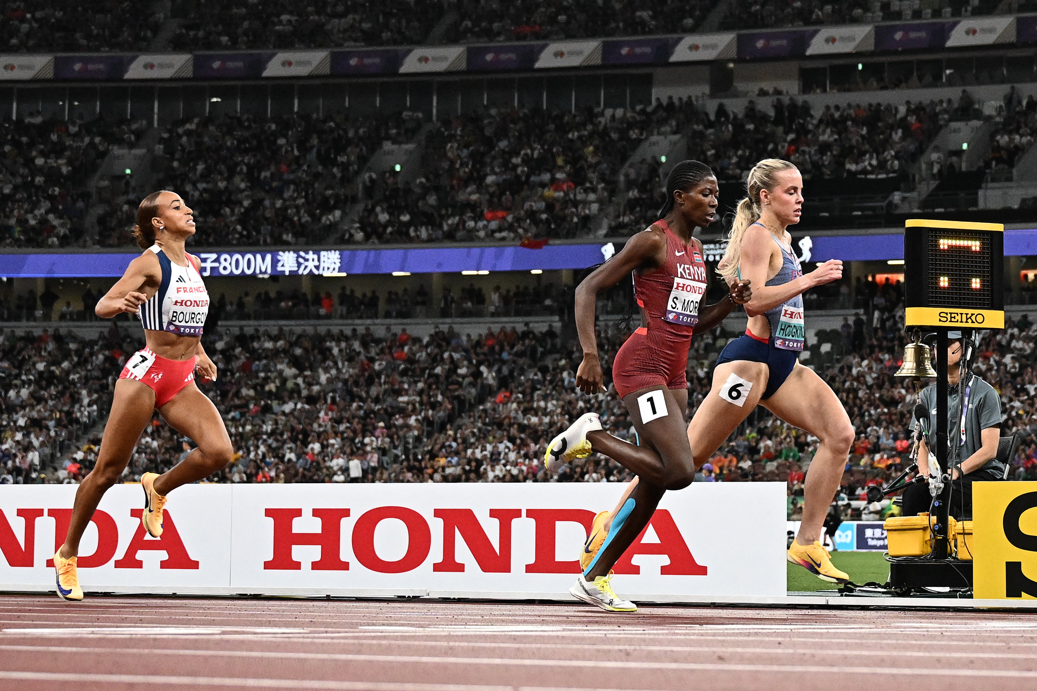 France's athlete Anais Bourgoin (L), Kenya's athlete Sarah Moraa and Great Britain's Keely Hodgkinson run to the finish line in the women's 800m semi-final