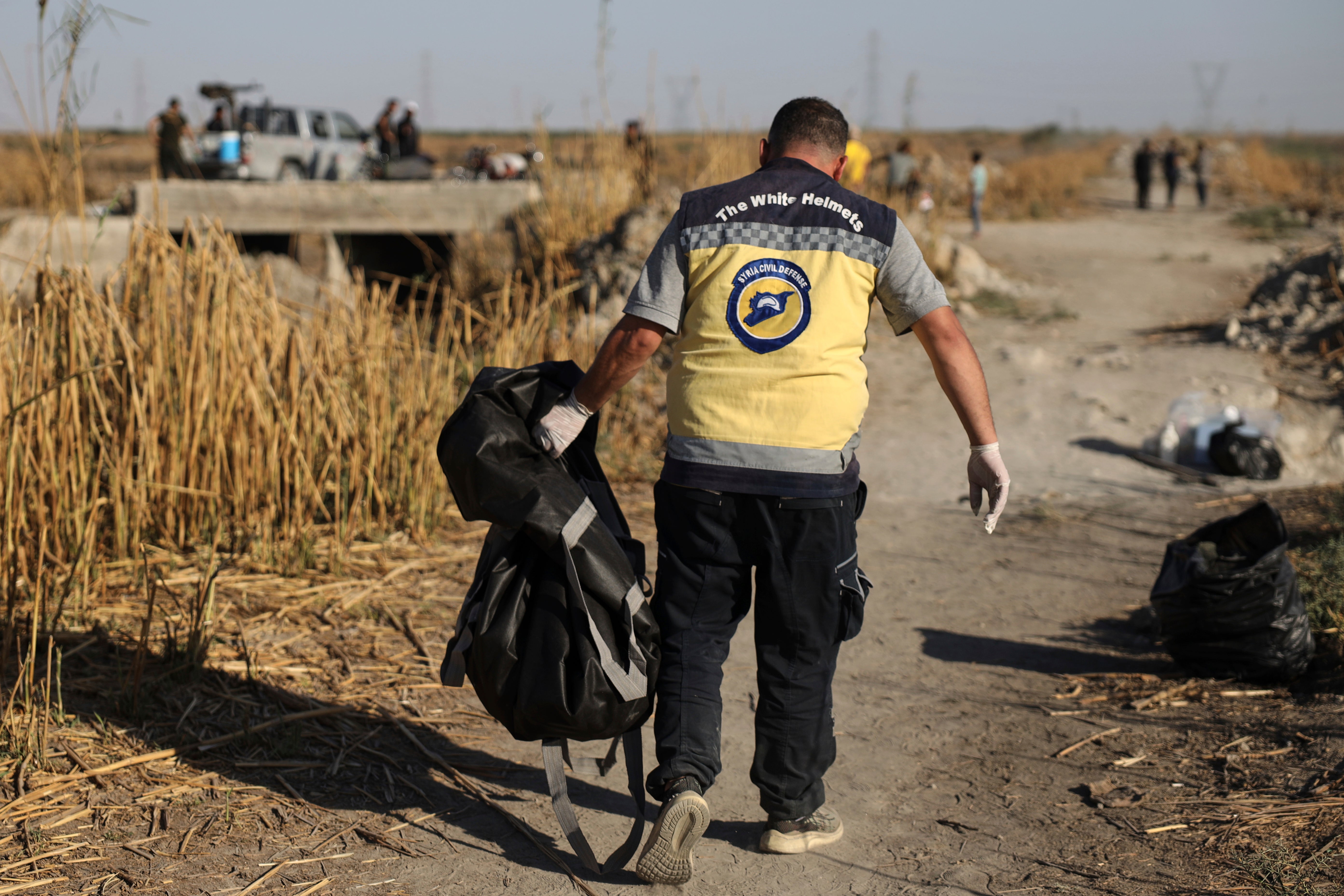 The White Helmets collect bodies from one mass grave site