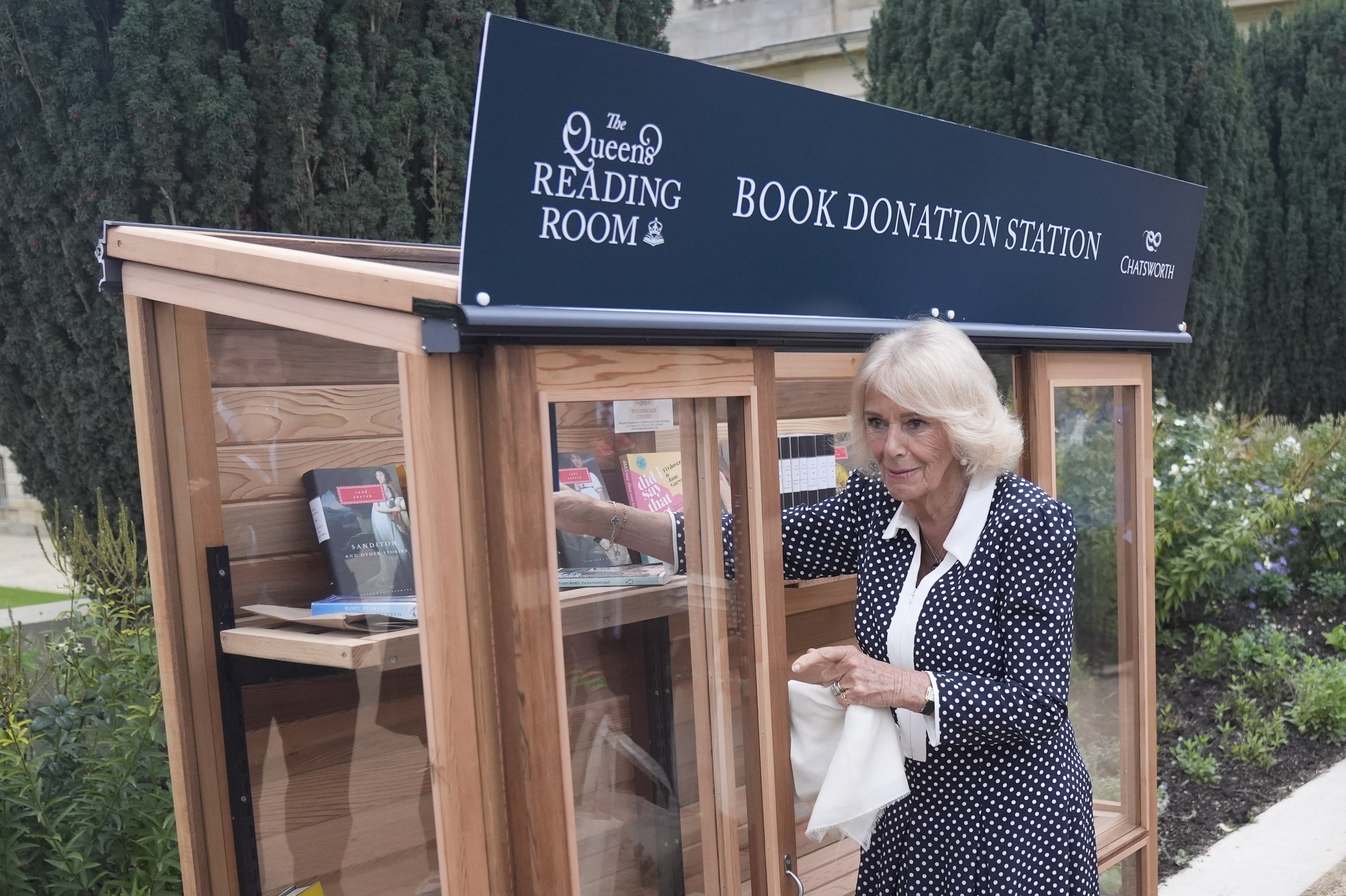 Camilla places books in a donation point for The Queen’s Reading Room
