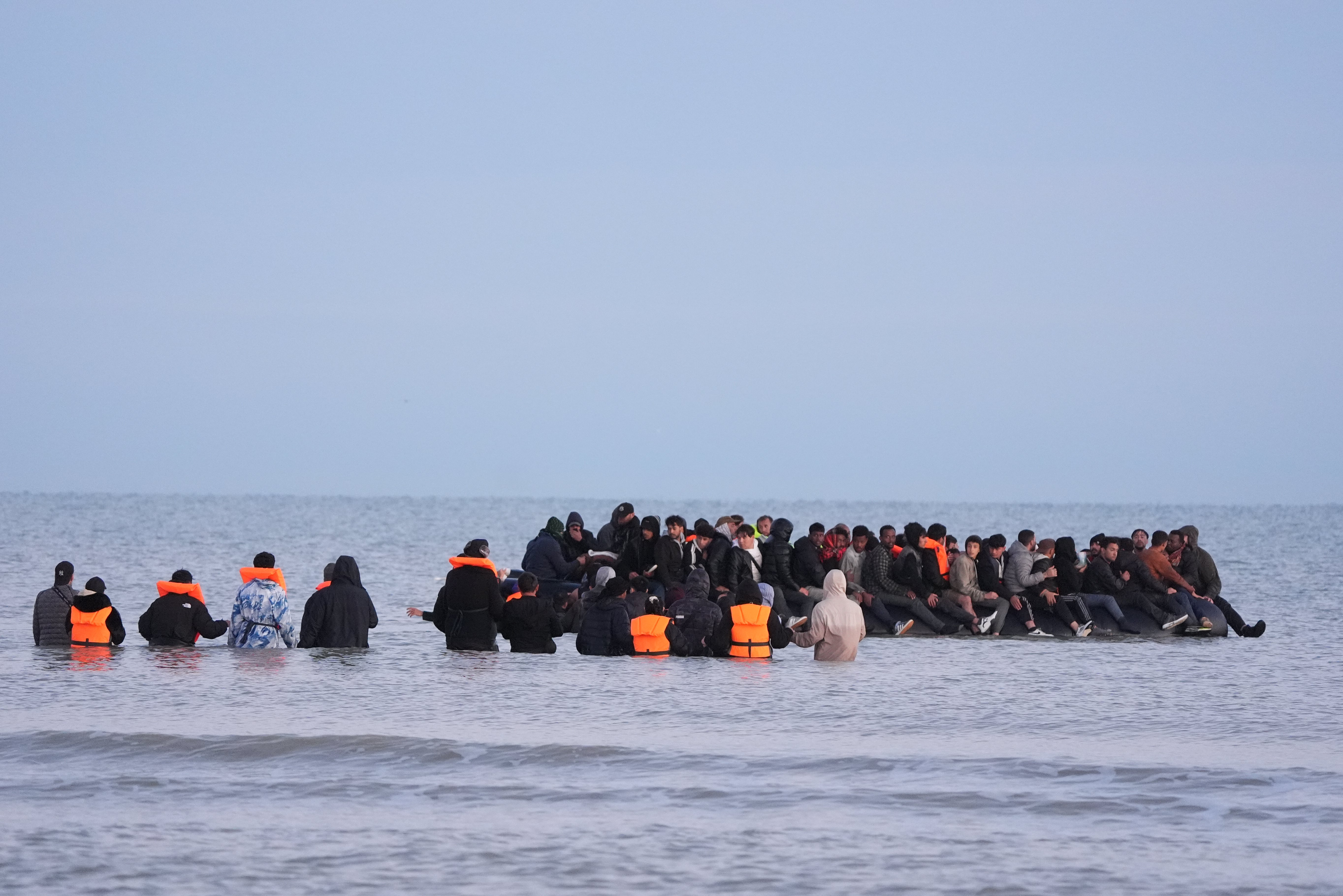 Migrants wade into the sea near Gravelines, France, to join a boat on Friday