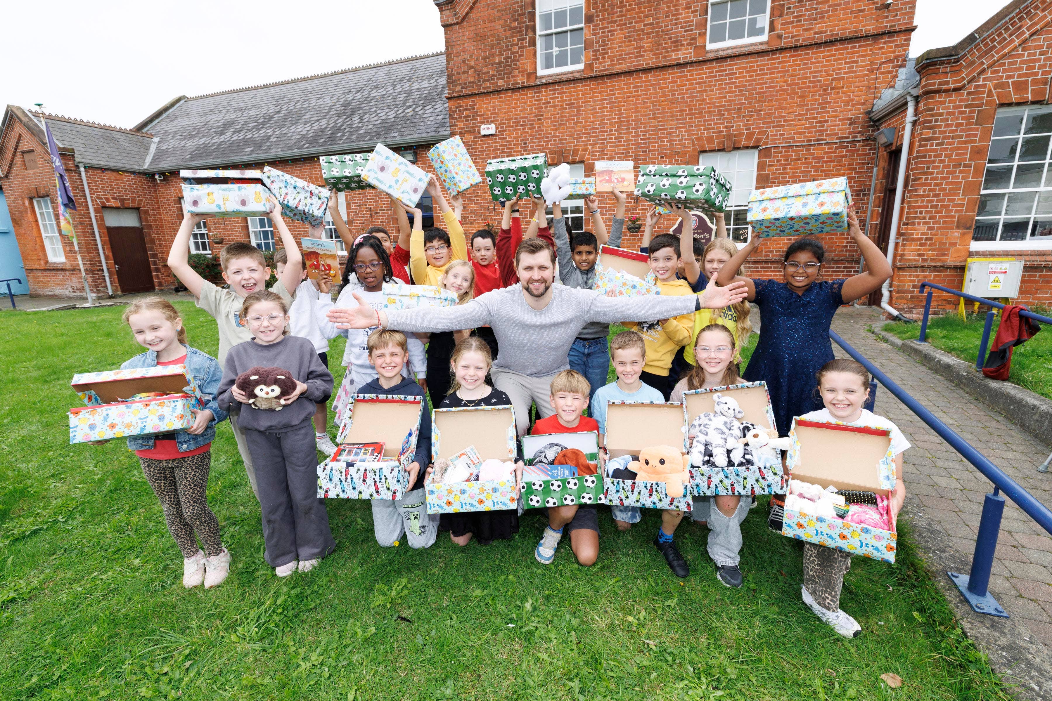Students from St. Peter’s NS Drogheda pictured with Adas Rakauskas, who received a Christmas shoebox as a child and is recreating the gesture for other children affected by poverty, three decades on (Andres Poveda/Mediaconsult/PA)