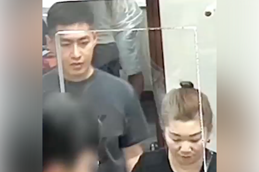 Roy Wang (left) and Qiuju Wu are seen on surveillance footage at a New York bank. The pair have been accused of stealing $2.8 million from a missing Long Island couple's bank account