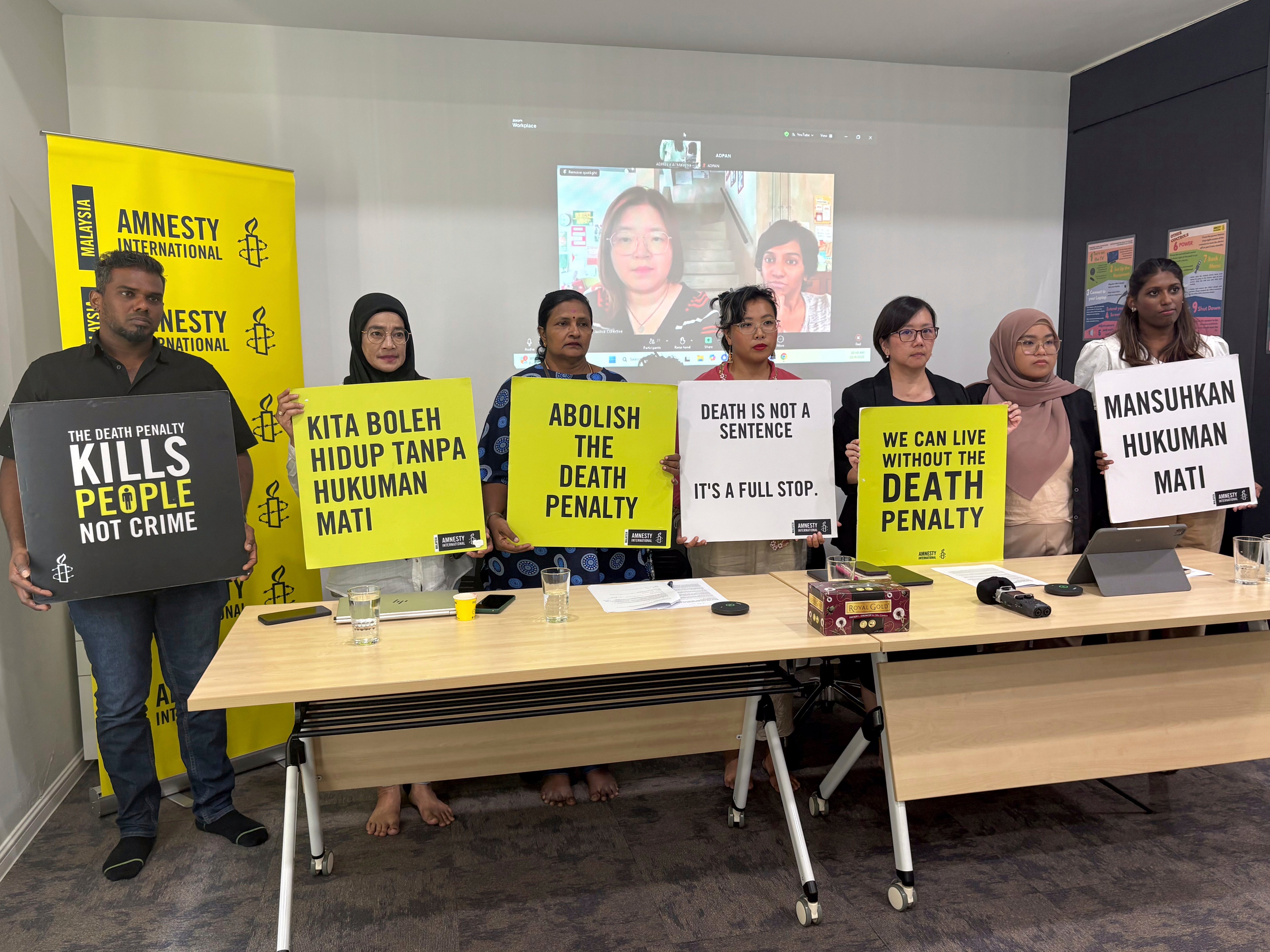 Nicole Fong, forth left, from Amnesty International Malaysia, holds a placard with others rights activists during a press conference in Kuala Lumpur, Malaysia, Monday, Sept. 22, 2025. (AP Photo/Eileen Ng)