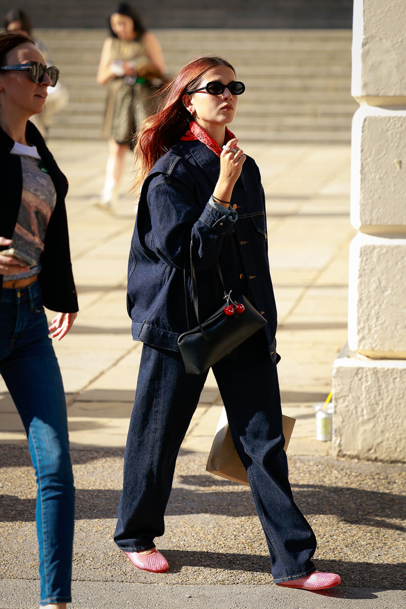 A guest wearing a red scarf, denim jacket and pants outside Fashion East during London Fashion Week on 19 September 2025 (photo by Hanna Lassen/Getty Images)