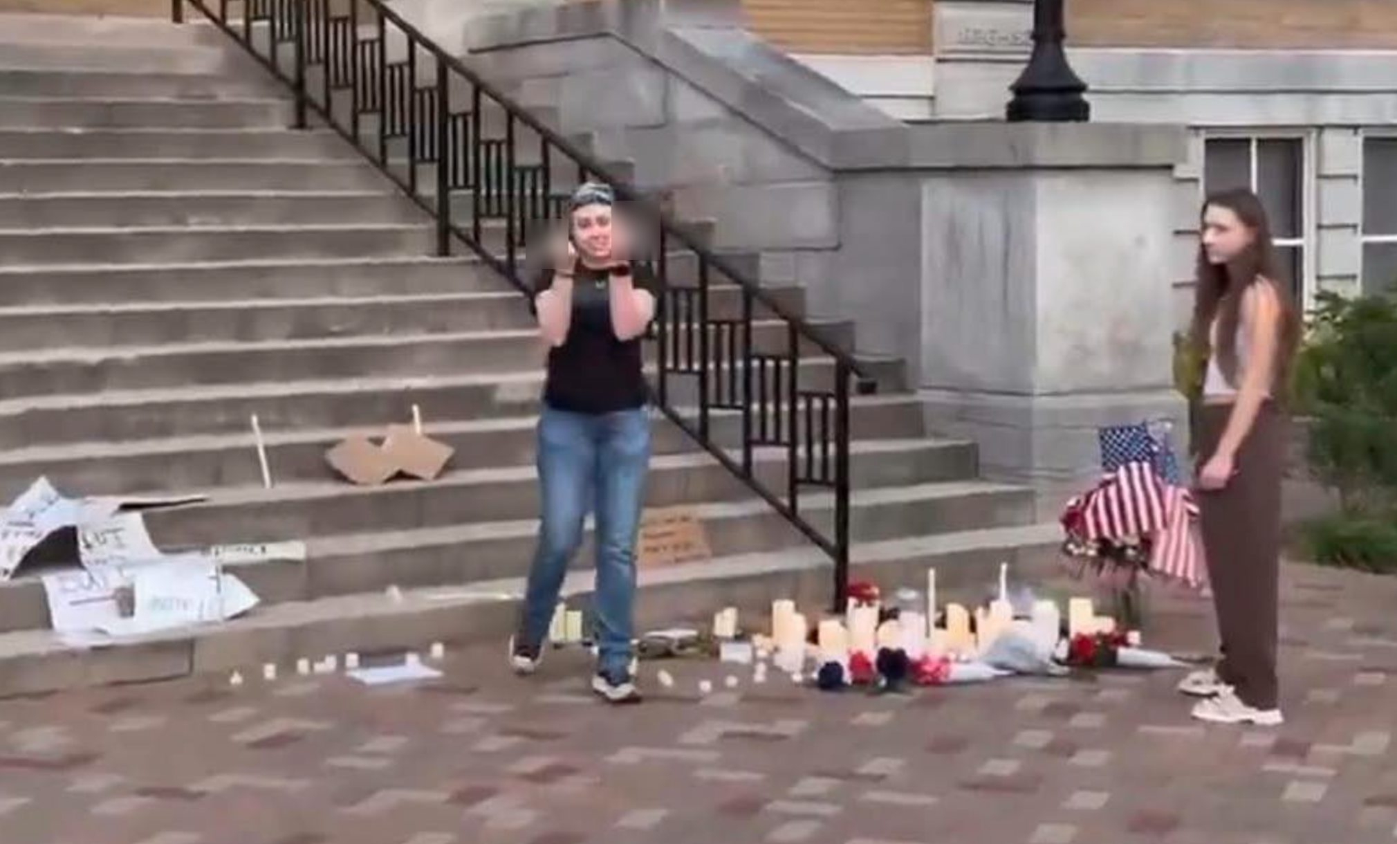 A woman identified by Benton County Sheriff's Deputies as Kerri Rollo makes an offensive gesture while allegedly vandalizing a memorial to Charlie Kirk in Bentonville, Arkansas. Her sister, identified by police as Kaylee Rollo, is also pictured. Both women were arrested and charged with criminal mischief