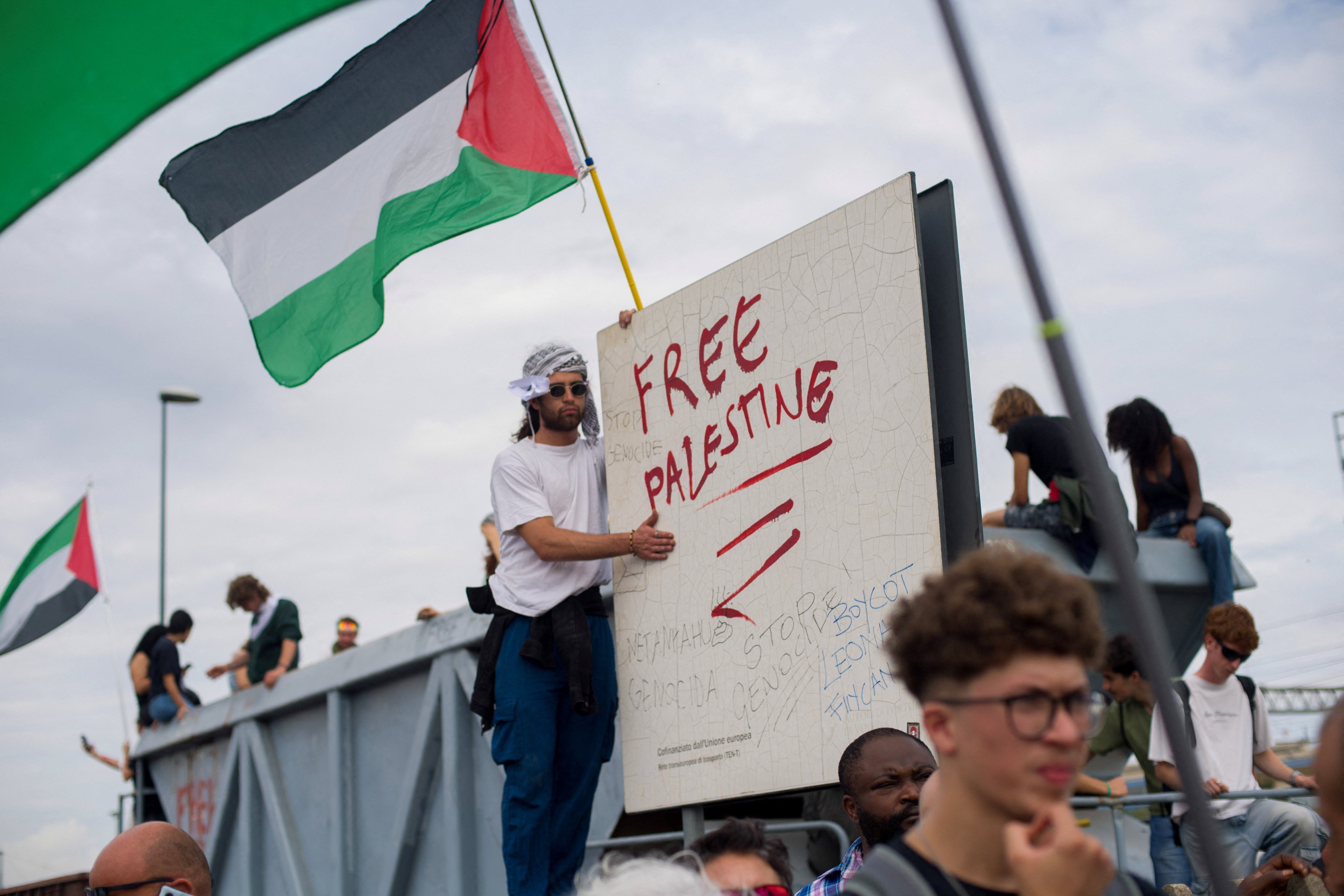 A protester stands next to a slogan reading "Free Palestine" during a demonstration that is part of a nationwide "Let's Block Everything" protest in solidarity with Gaza