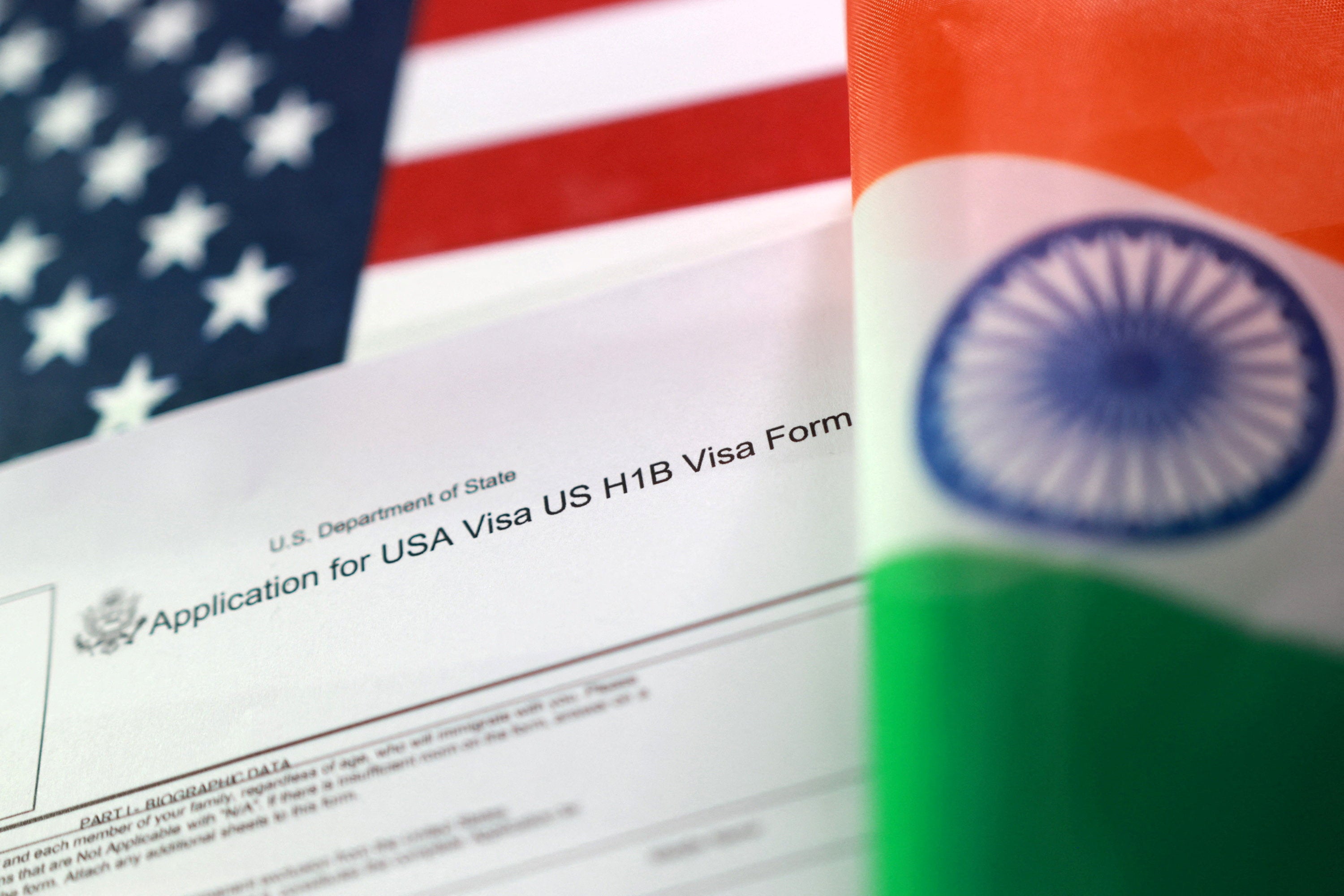 U.S. and Indian flags and a U.S. H-1B Visa application form are seen in this illustration taken, September 22, 2025