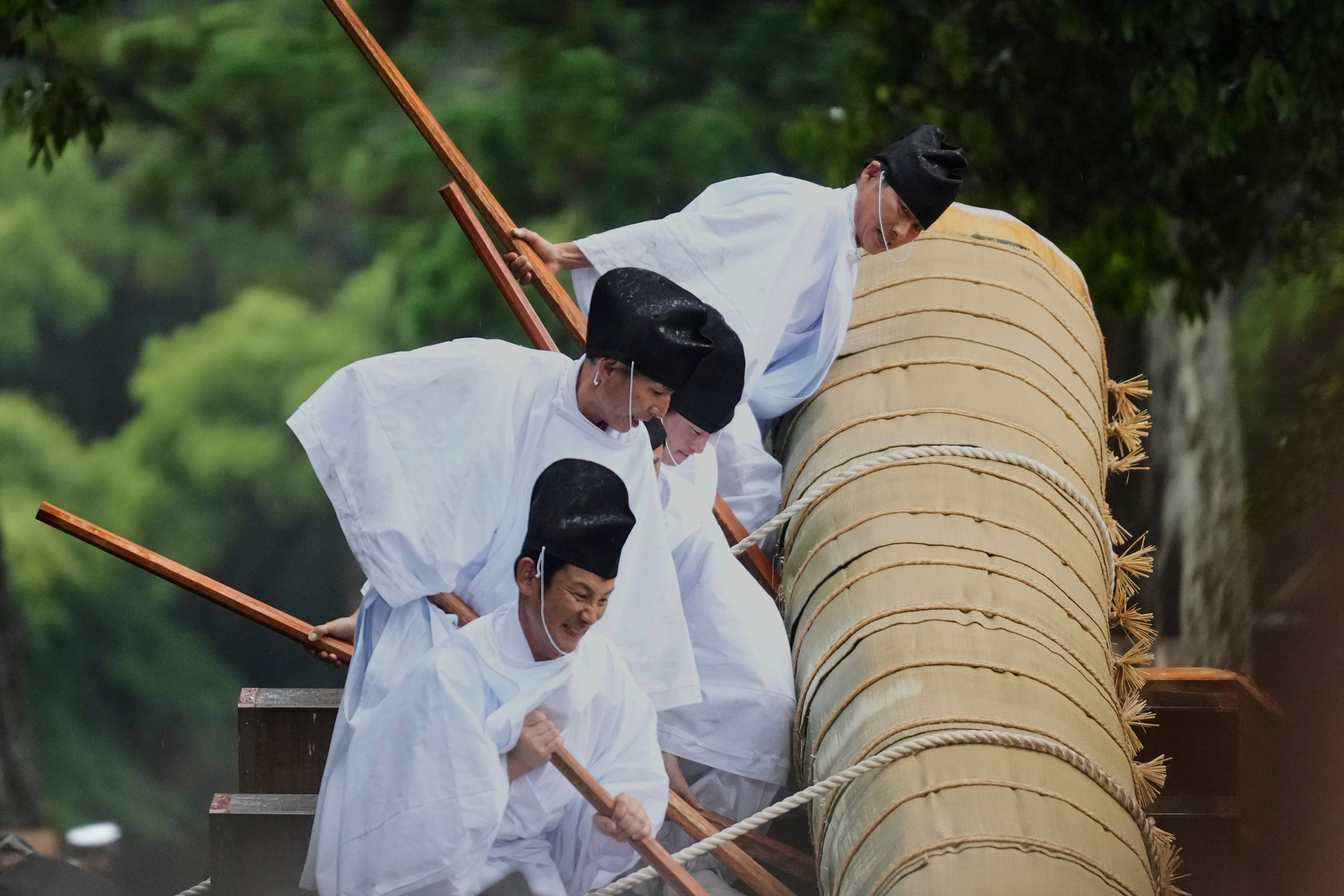 Members of the Shinto priesthood try to push down a sacred timber from a wheeled platform at the end of Mihishirogi Hoeishiki, a ceremony held during the rebuild of the sacred Ise Jingu shrine