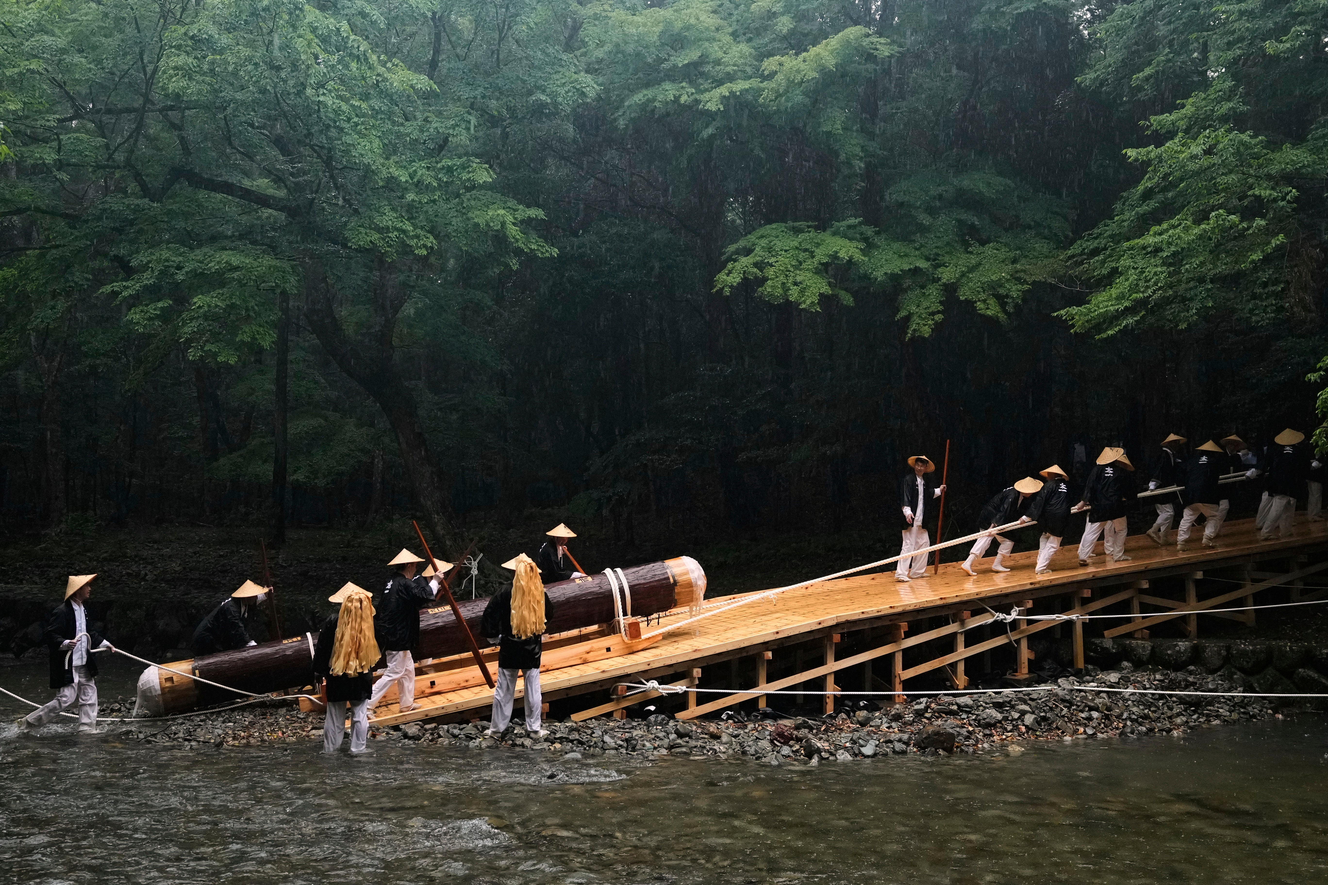People pull a sacred timber up from a creek, carrying into the Kotaijingu, also known as Naiku, or the inner sanctuary, of the Ise Jingu shrine complex
