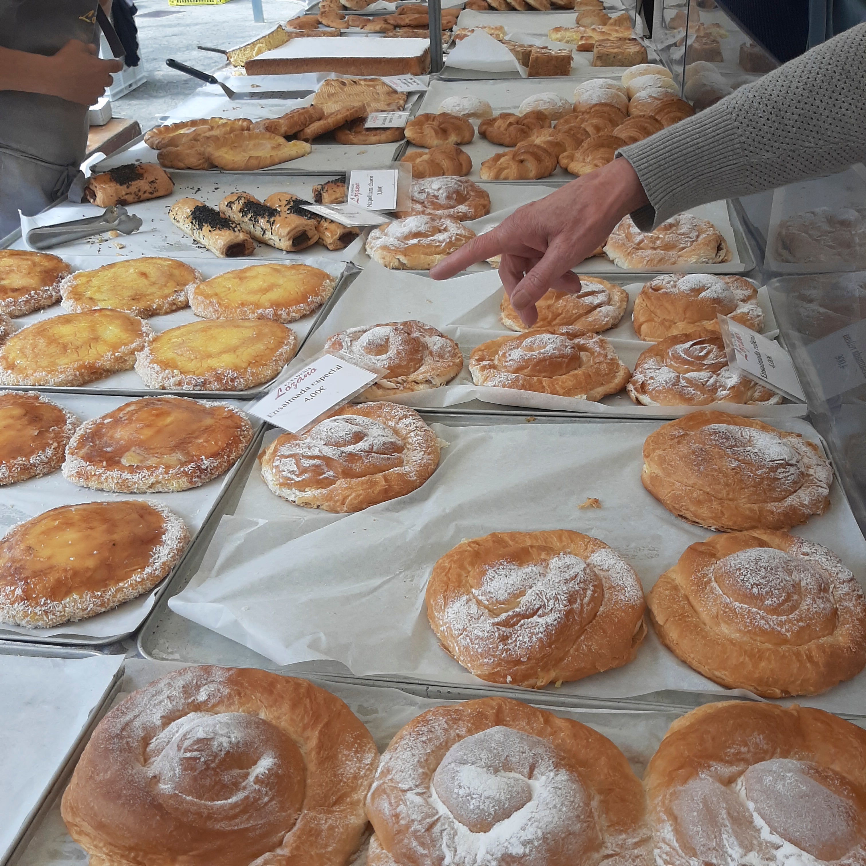 At Sineu market in Mallorca, ensaimada pastries are on display. This coiled flaky pastry is one of the most iconic pastries in Spain