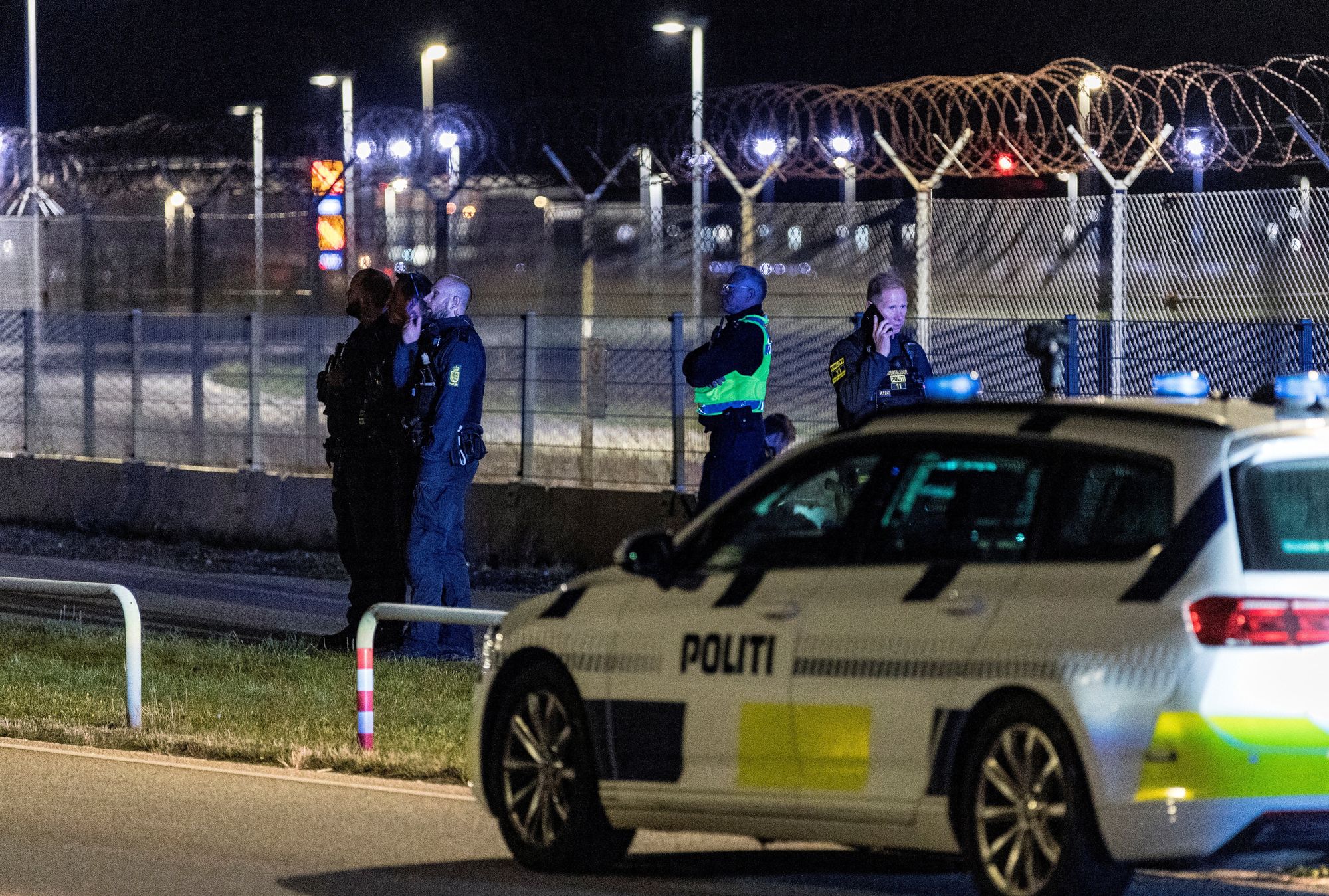 Police officers stand guard after all traffic was closed at the Copenhagen airport due to drone reports