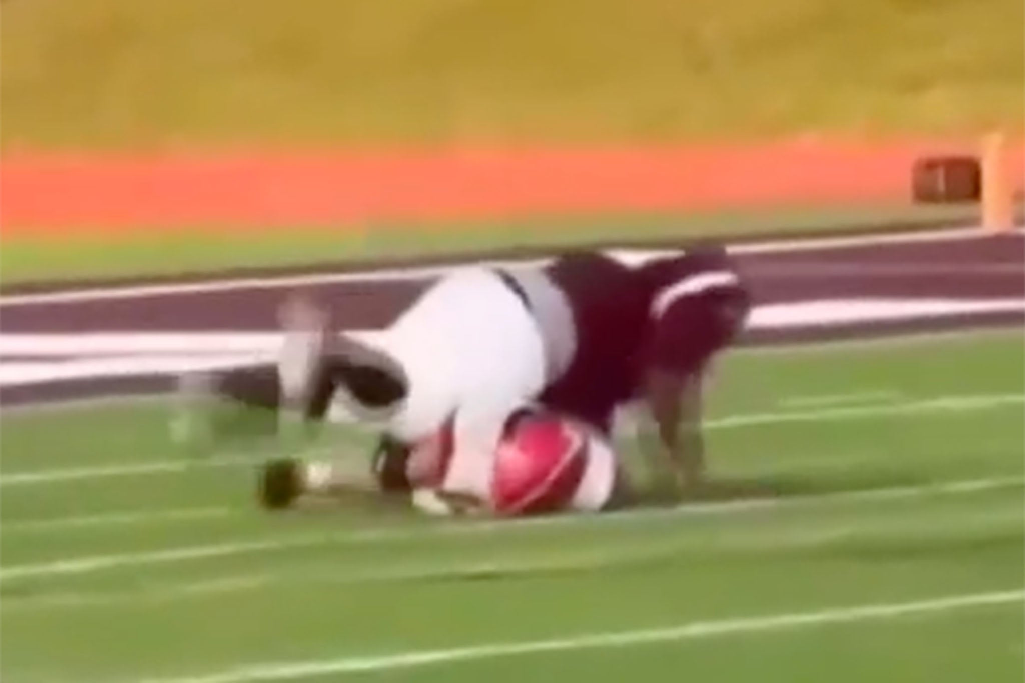 A screengrab from the video showing a Kalamazoo player jumping on top of a Lakeshore football player
