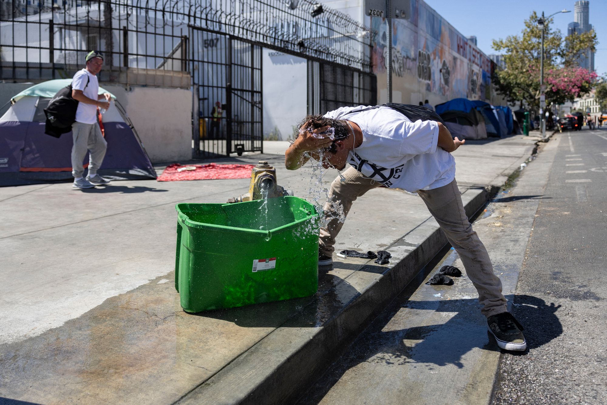 A man splashes his face with water during a heatwave in California.