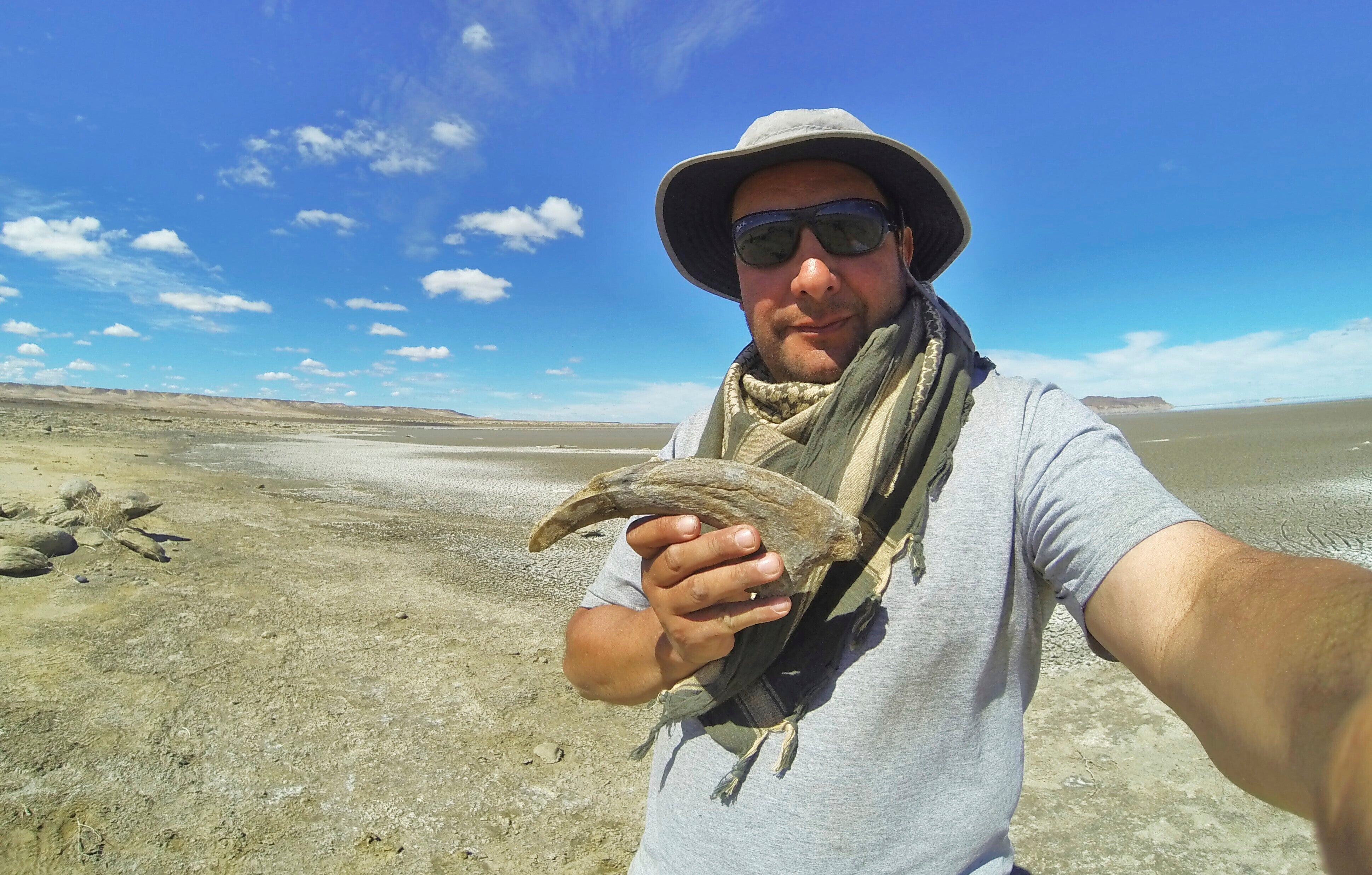 This undated image provided shows researcher Marcelo Luna holding a claw belonging to a type of dinosaur called a megaraptoran in Chubut, Argentina
