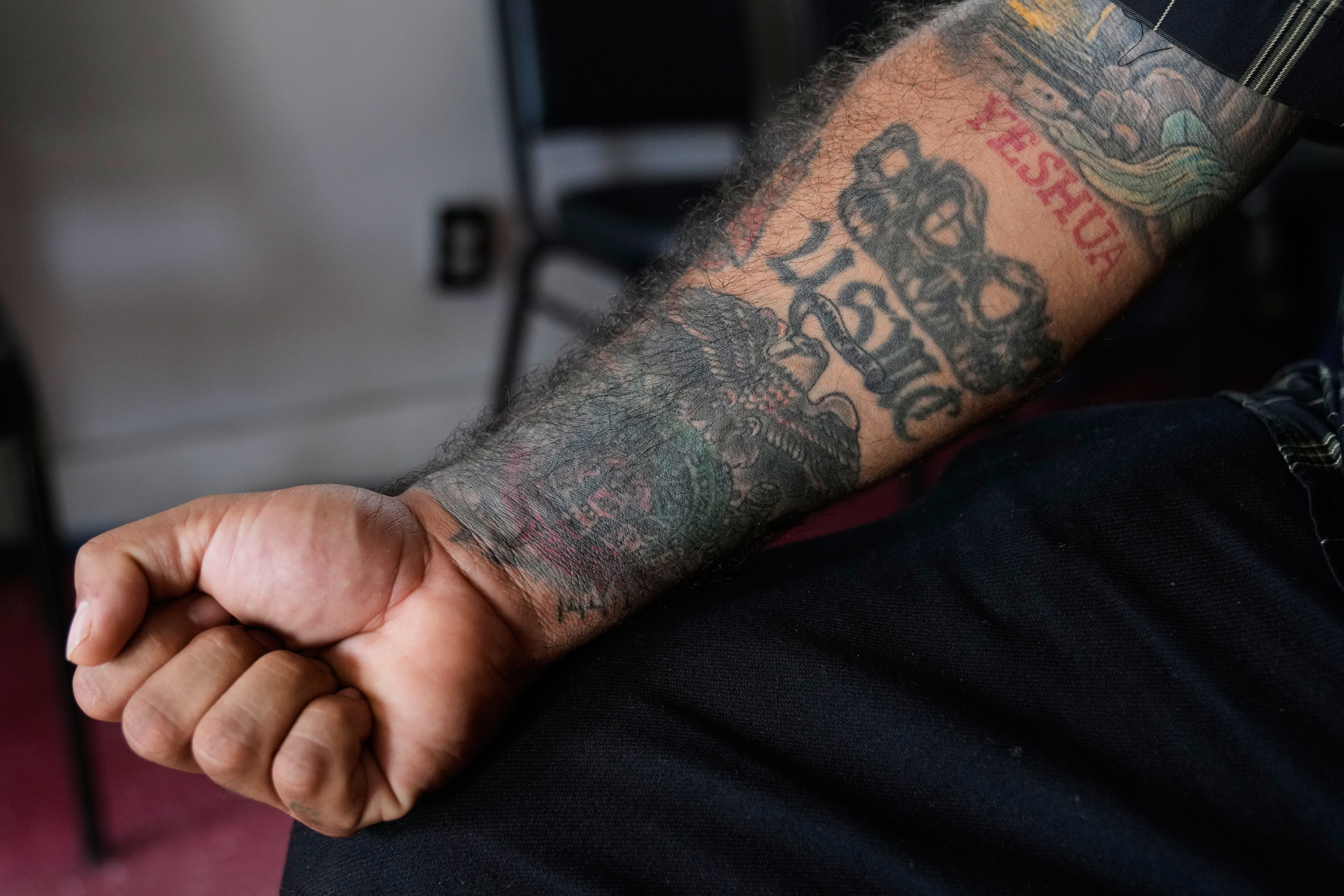 Julio Torres shows his USMC tattoo as he poses for a photo inside Serenity Corner, a church he founded nearly a decade ago