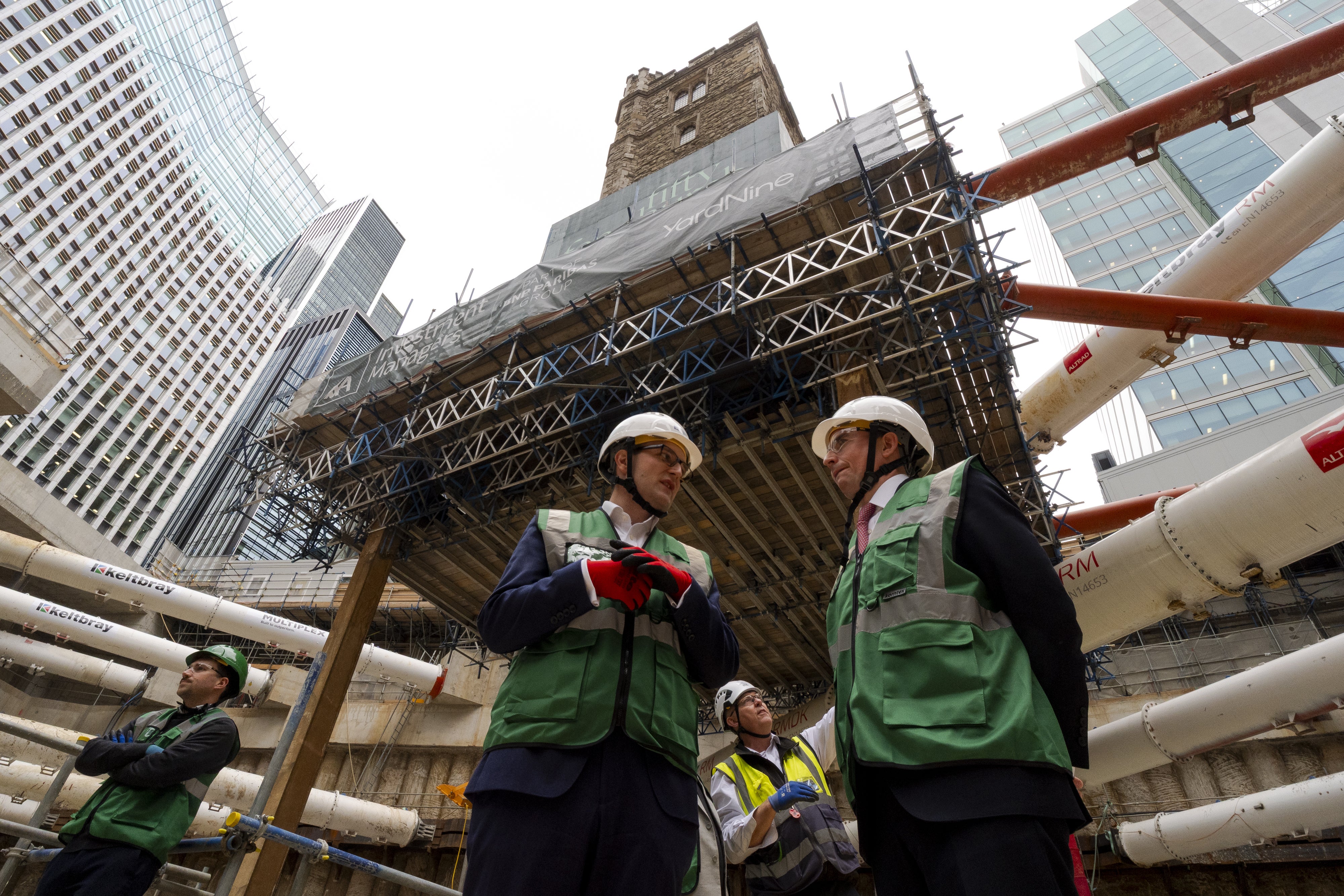 People stand beneath the 700-year-old tower of All Hallows Staining