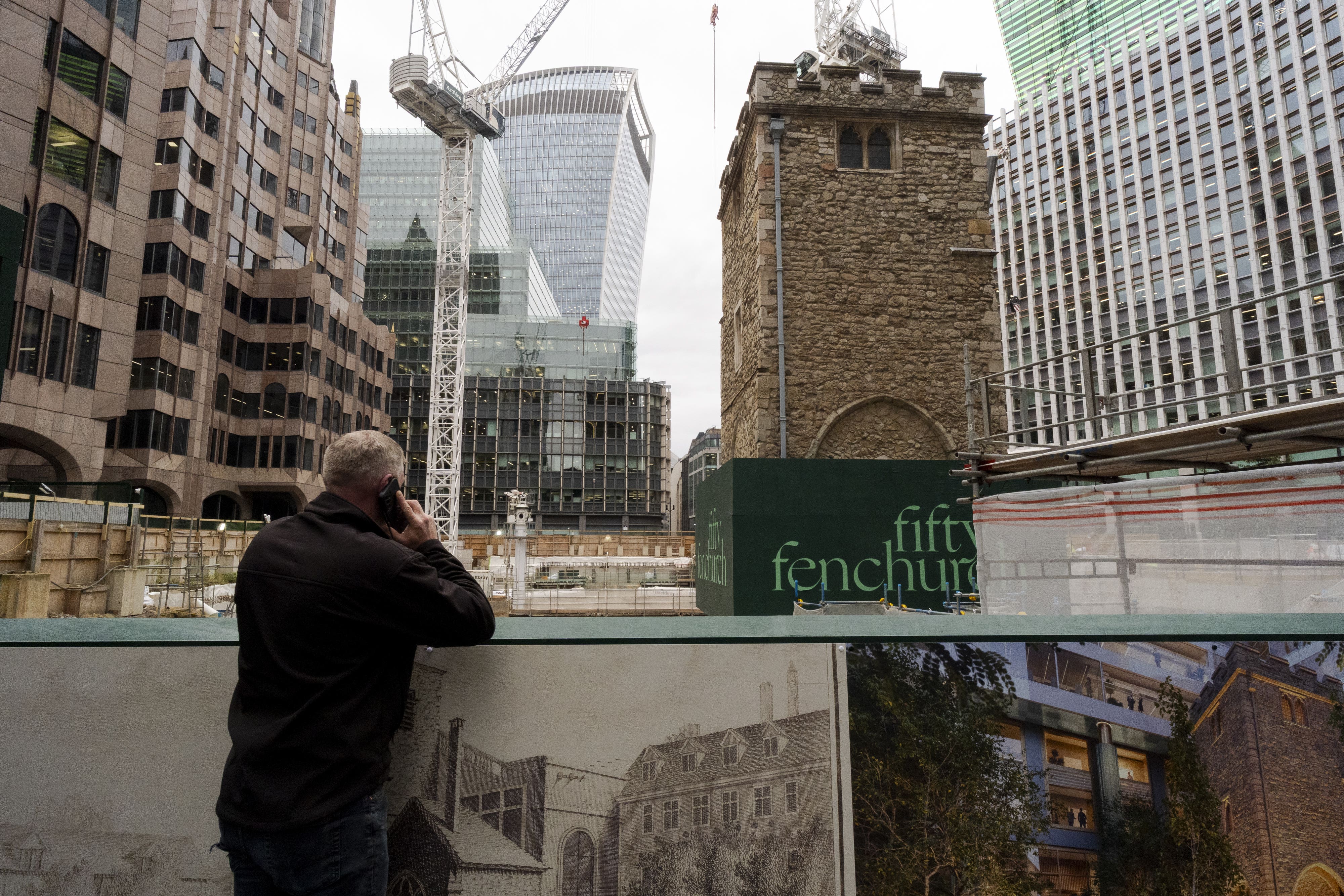 A person looks on as the 700-year-old tower of All Hallows Staining church is elevated on stilts during the Bottoming Out ceremony (Jordan Pettitt/PA)
