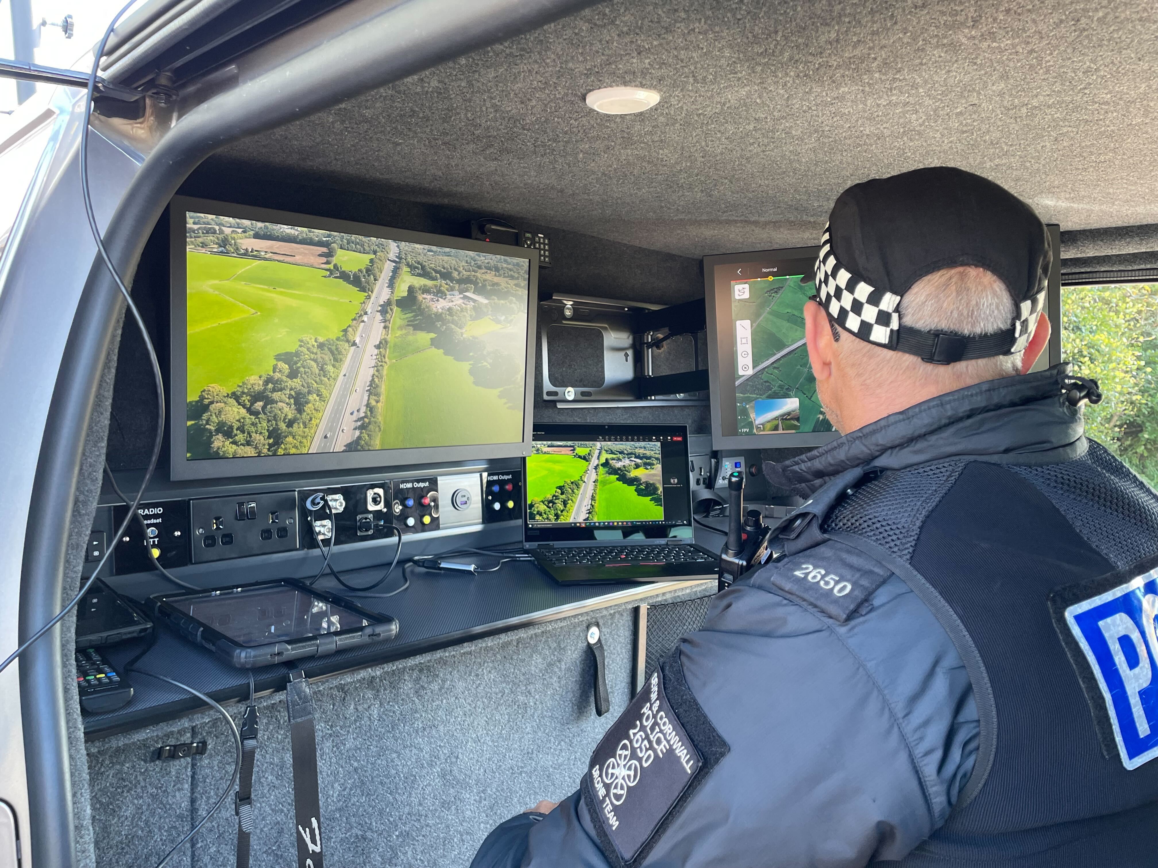 PC Tim Brooks sits inside a police van monitoring footage being captured by a drone above the M5 in Devon
