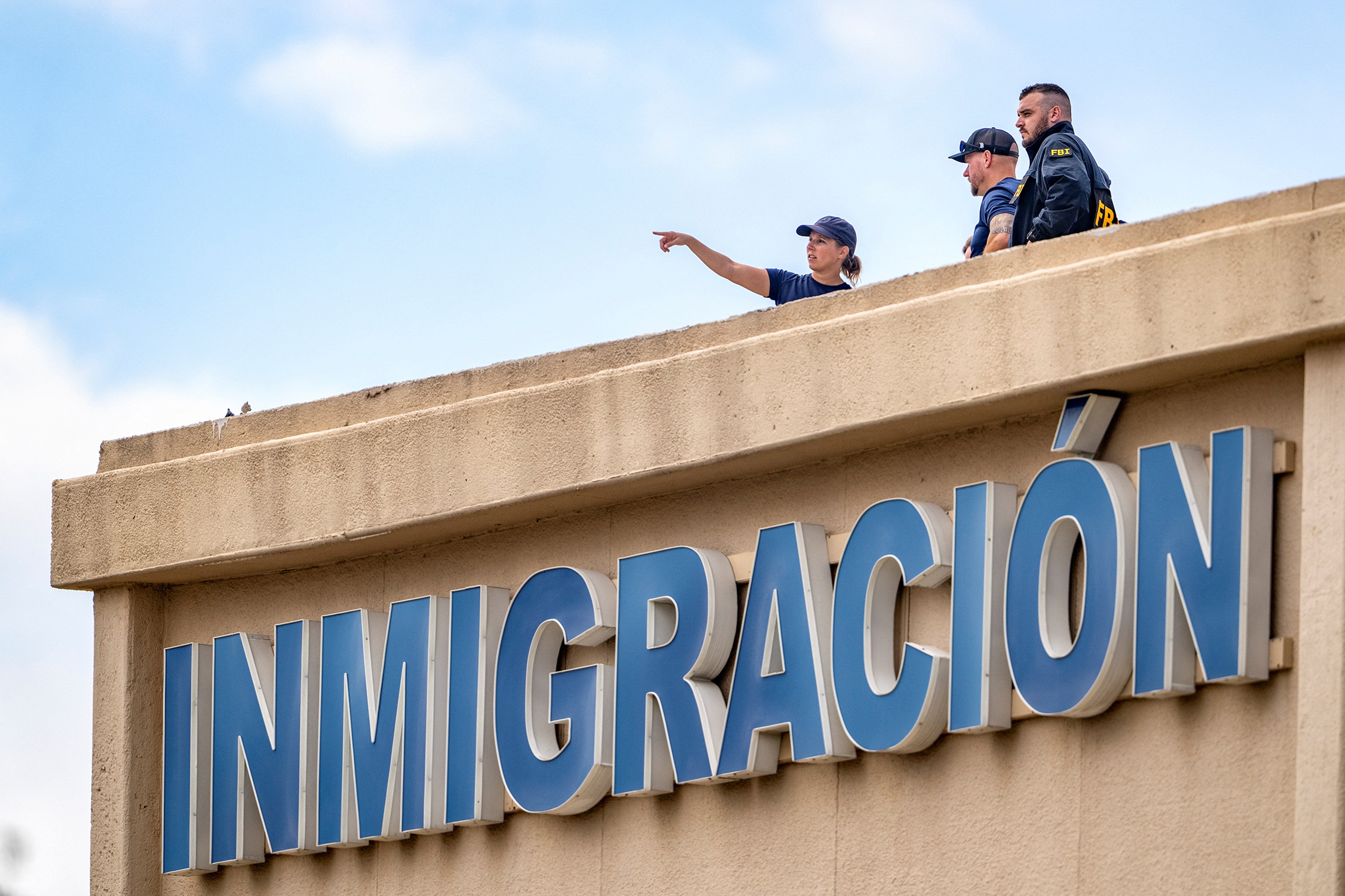 FBI agents on the roof of an immigration lawyer's office building across the street from the ICE field office