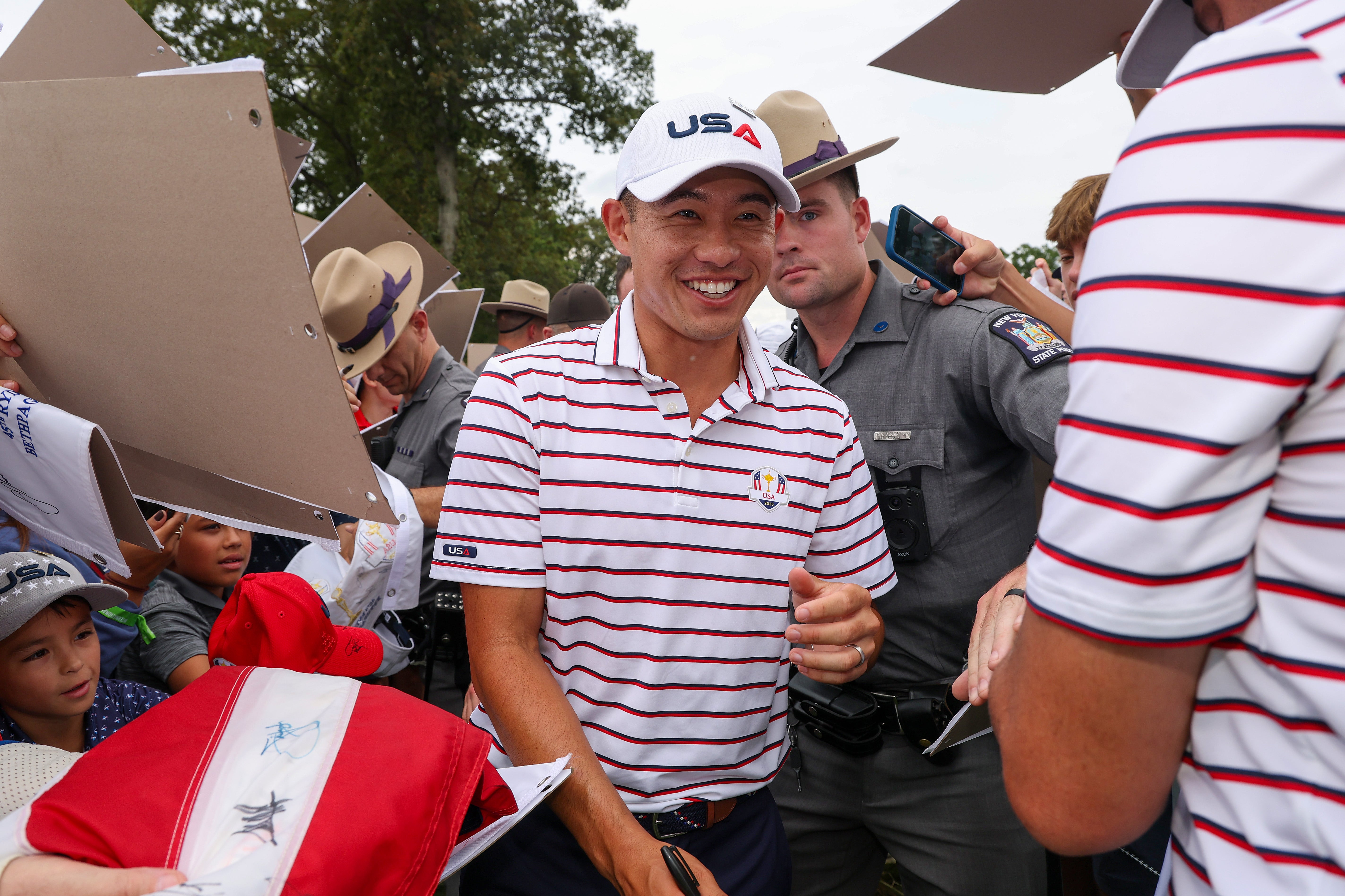 Collin Morikawa of Team United States signs autographs during a practice round