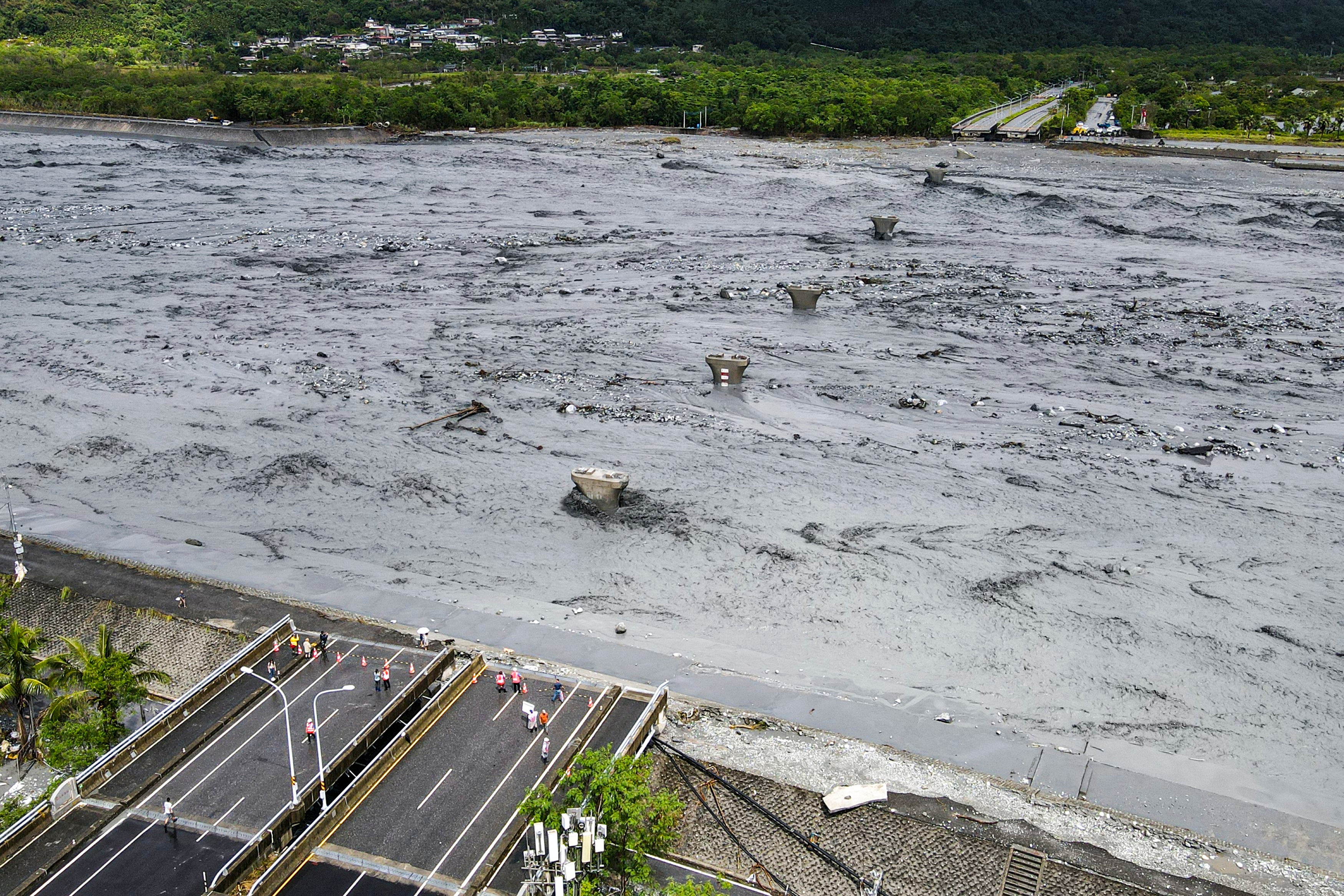 An overview shows flowing mud and floodwaters after a barrier lake burst and caused parts of the bridge over Mataian Creek be destroyed in Hualien