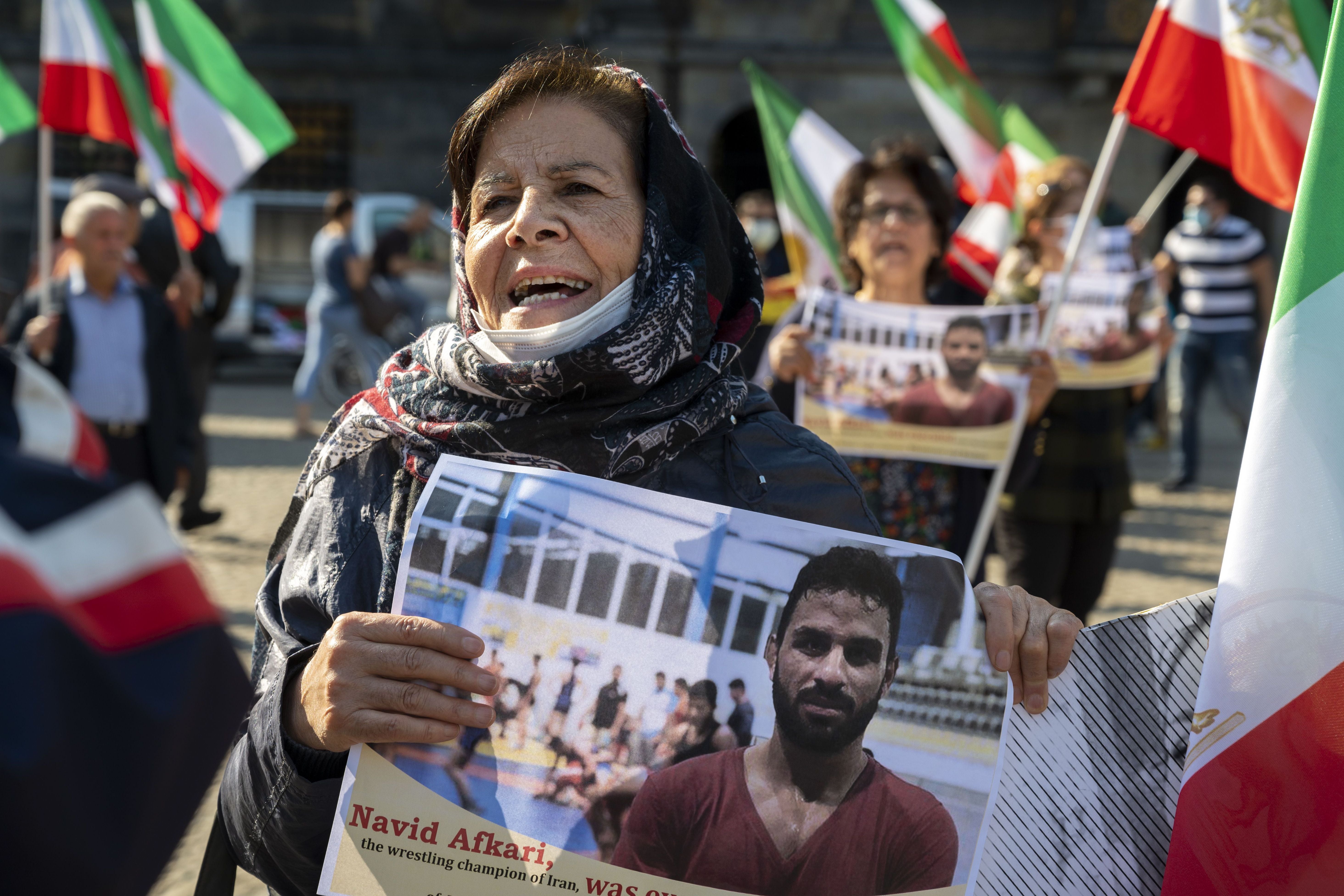 A woman holds a portrait of Iranian wrestler Navid Afkari, who was sentenced to death in 2020
