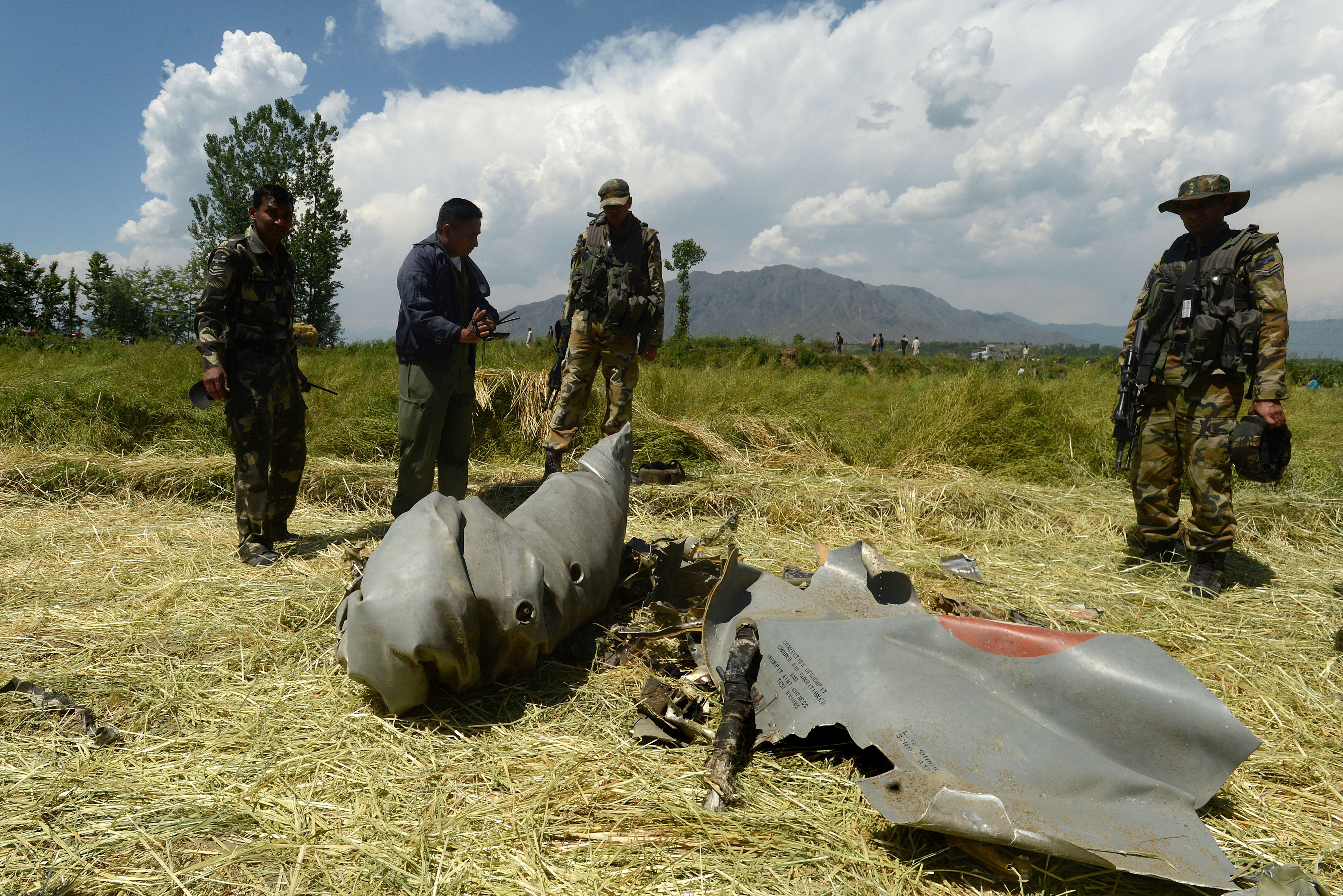 Indian soldiers inspect the wreckage of a MiG-21 that crashed in Anantnag district of Kashmir on 27 May 2014