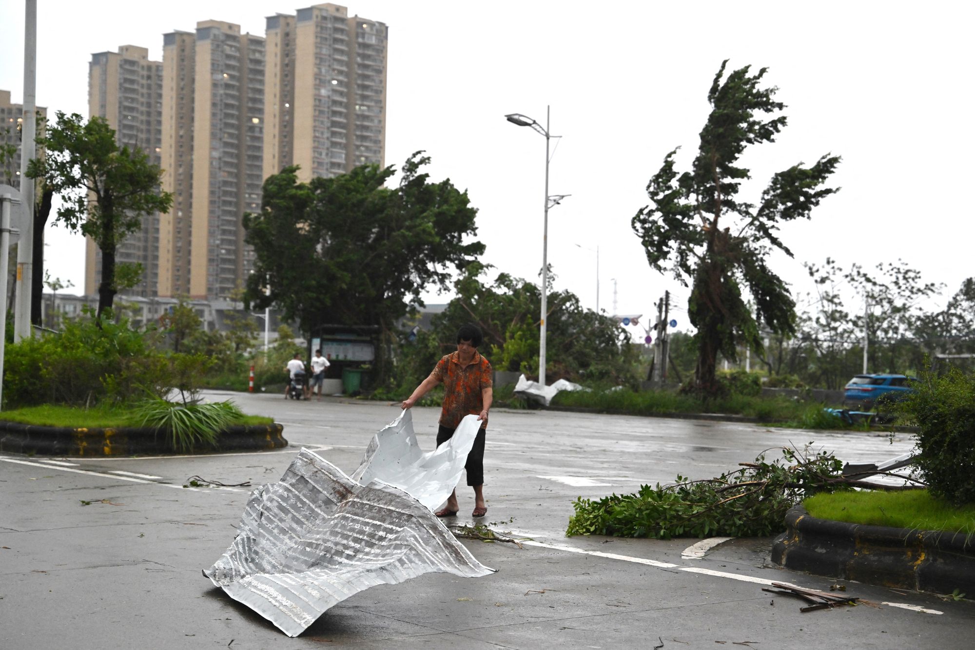 A woman clears debris after the passing of Ragasa in Yangjiang, southern China's Guangdong province, on 24 September 2025